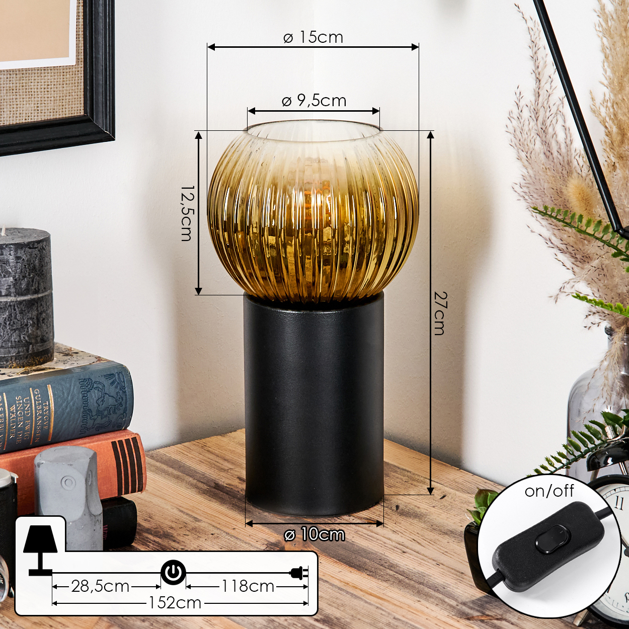 Eine dekorative Lampe mit goldenem Glasschirm steht auf einem schwarzen Sockel. Maße sind angegeben. Bücher und eine Kerze befinden sich im Hintergrund.