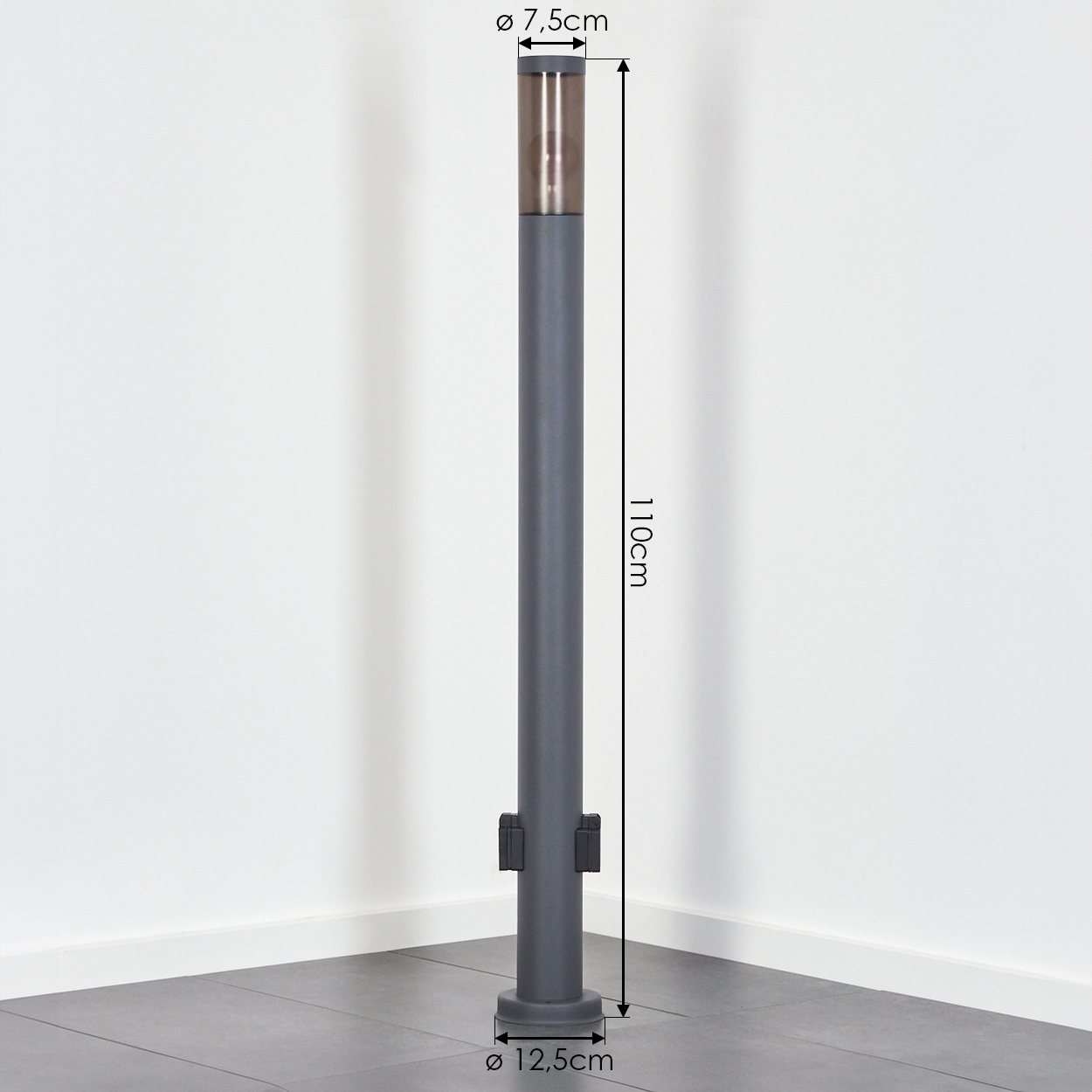 Ein grauer Poller mit braunem Oberteil steht auf einem Fliesenboden. Er ist 110 cm hoch, mit 7,5 cm oben und 12,5 cm Basis.