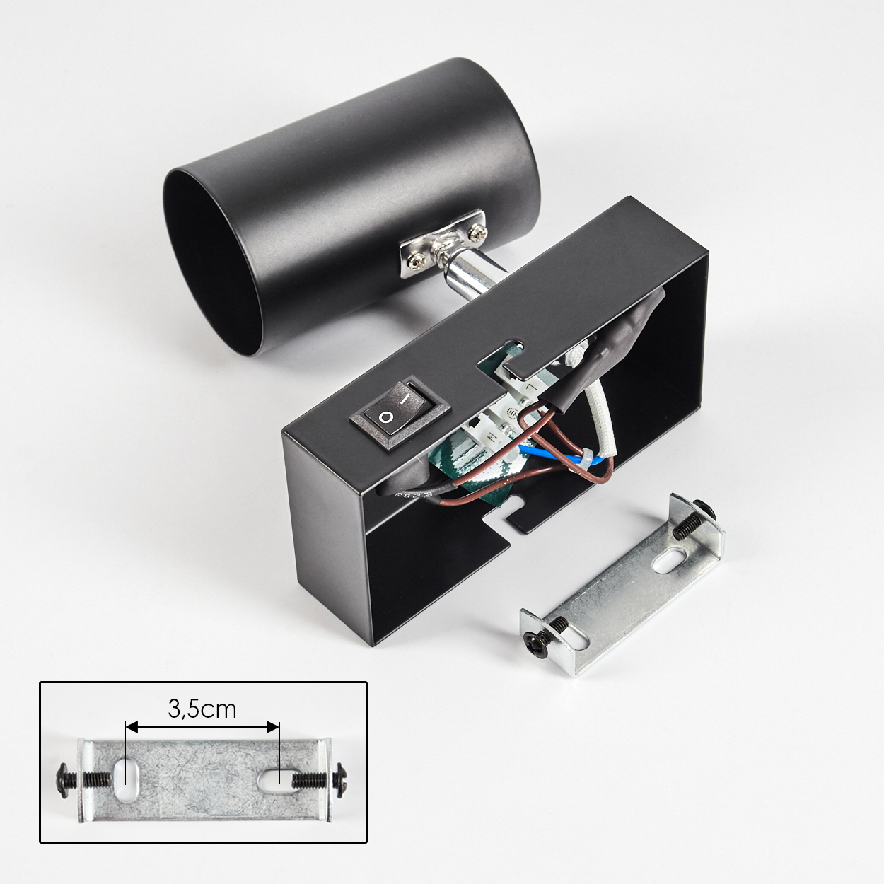 Schwarze zerlegte Lampe auf Weiß. Zeigt einen zylindrischen Kopf, eine rechteckige Basis mit Schalter und eine Metallhalterung.