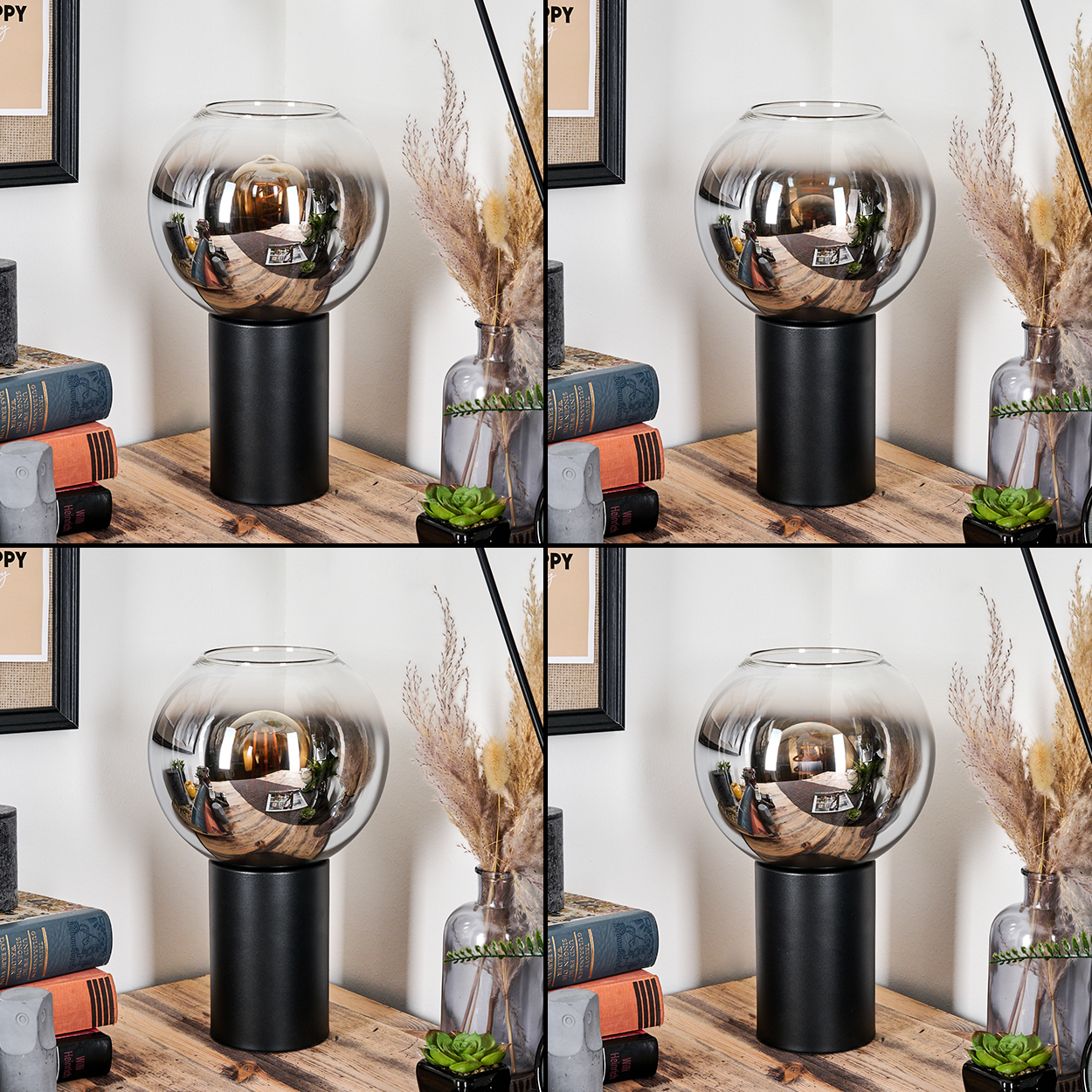 Eine dekorative Lampe mit Glaskugel steht auf einem Tisch. Bücher, eine kleine Pflanze und eine Vase mit Trockenblumen sind ebenfalls auf dem Tisch.