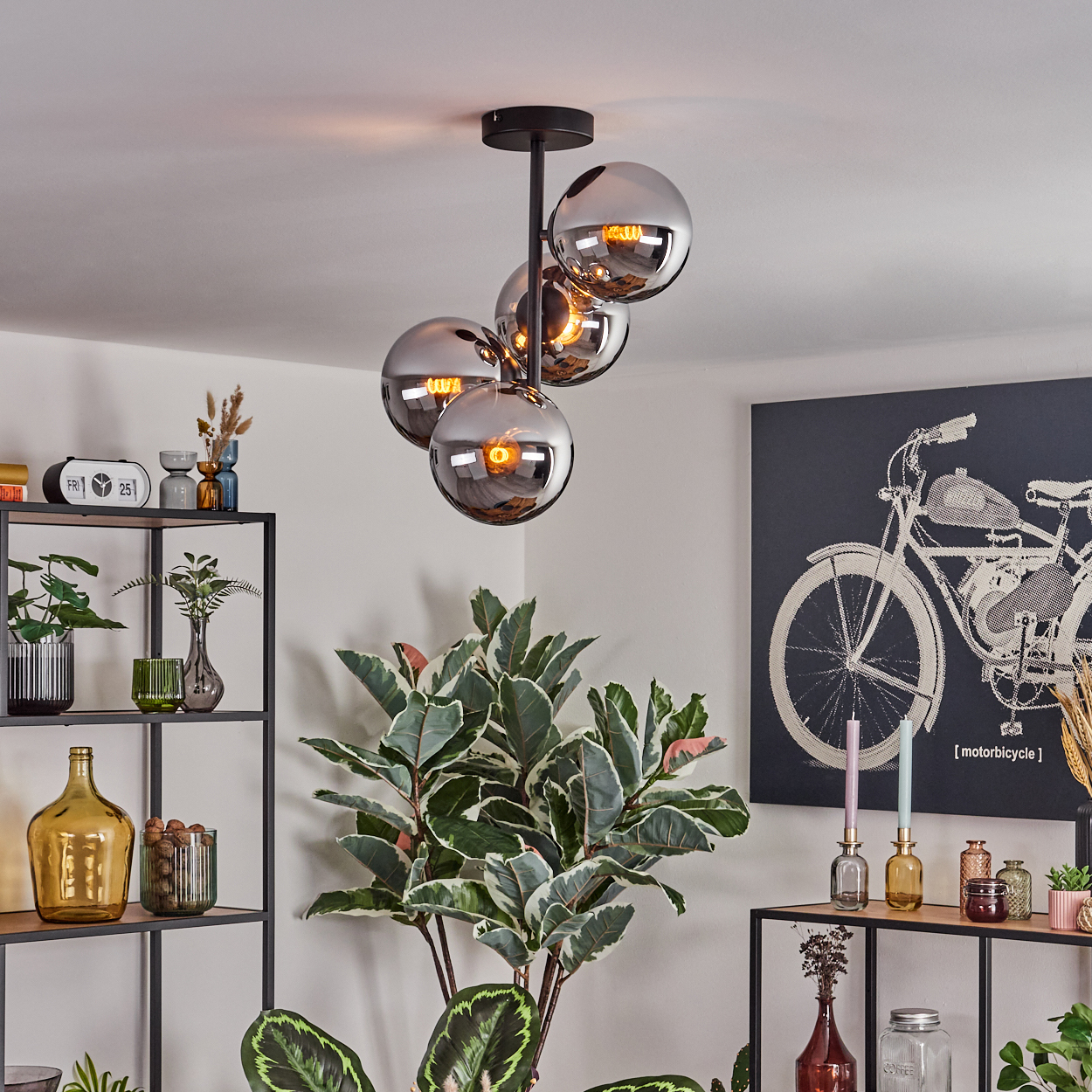 Ein modernes Wohnzimmer mit einer Chrom-Leuchte, einer großen Pflanze und einem Kunstwerk eines Motorrads. Regale halten Dekorationen.