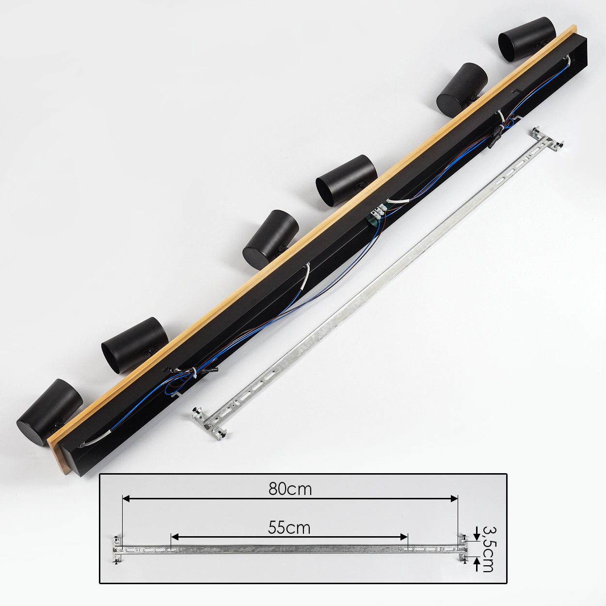 Schwarze und holzfarbene Leuchte mit sechs zylindrischen Strahlern, Drähten und einer Metallhalterung. Maße sind in cm angegeben.