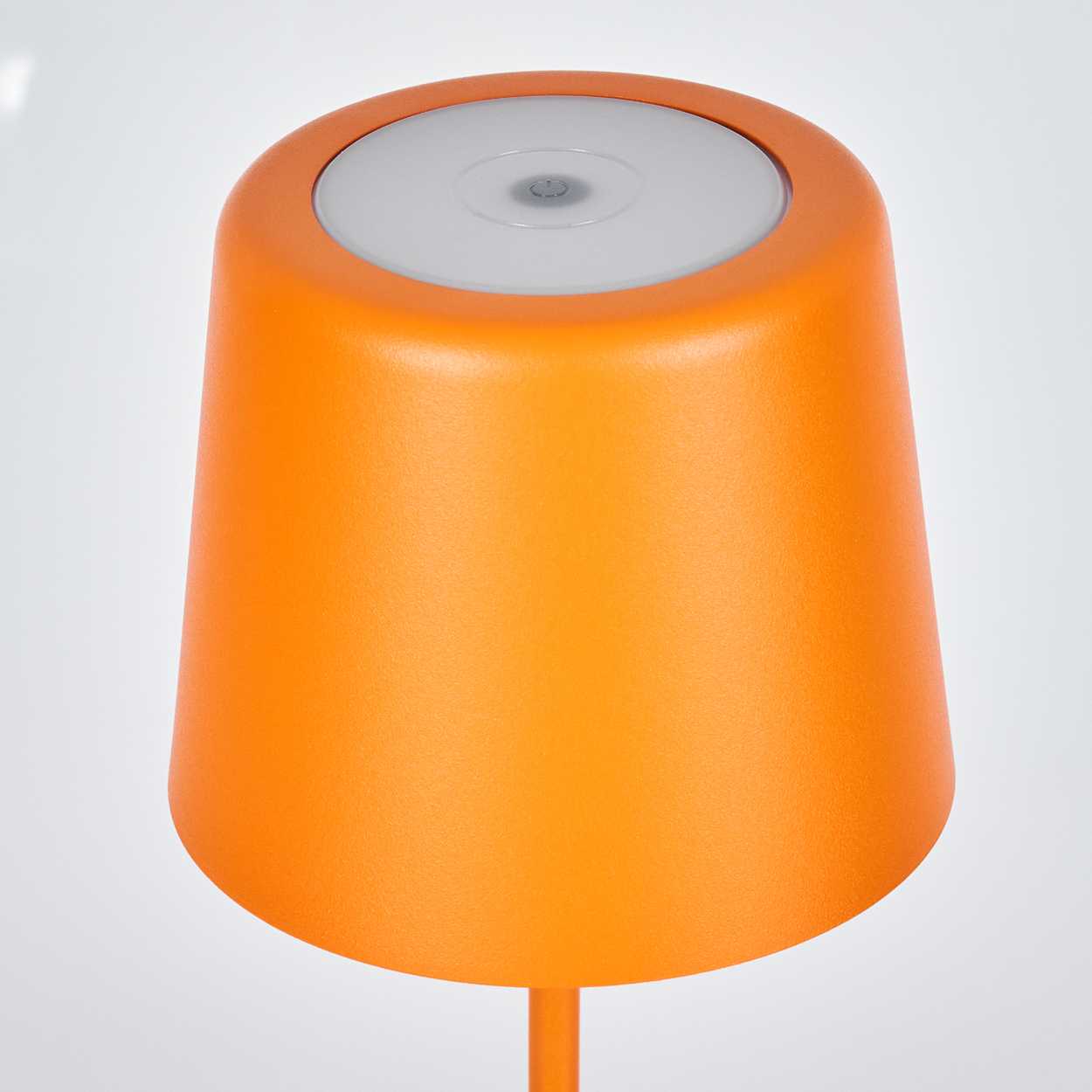 Eine orangefarbene Lampe mit abgerundetem Schirm. Die Lampe hat eine weiße Lichtquelle oben. Sie befindet sich auf weißem Hintergrund.