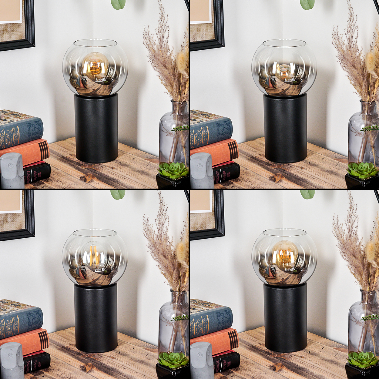 Eine Lampe mit Glaskugel auf schwarzem Sockel steht auf Holz. Bücher, eine Vase mit Trockenpflanzen und eine kleine Pflanze sind in der Nähe.
