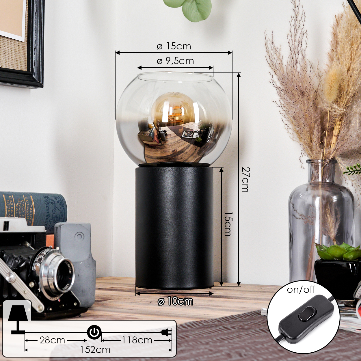 Eine dekorative Lampe mit Glaskugel, die eine Glühbirne enthält, auf einem schwarzen zylindrischen Sockel und Schalter.