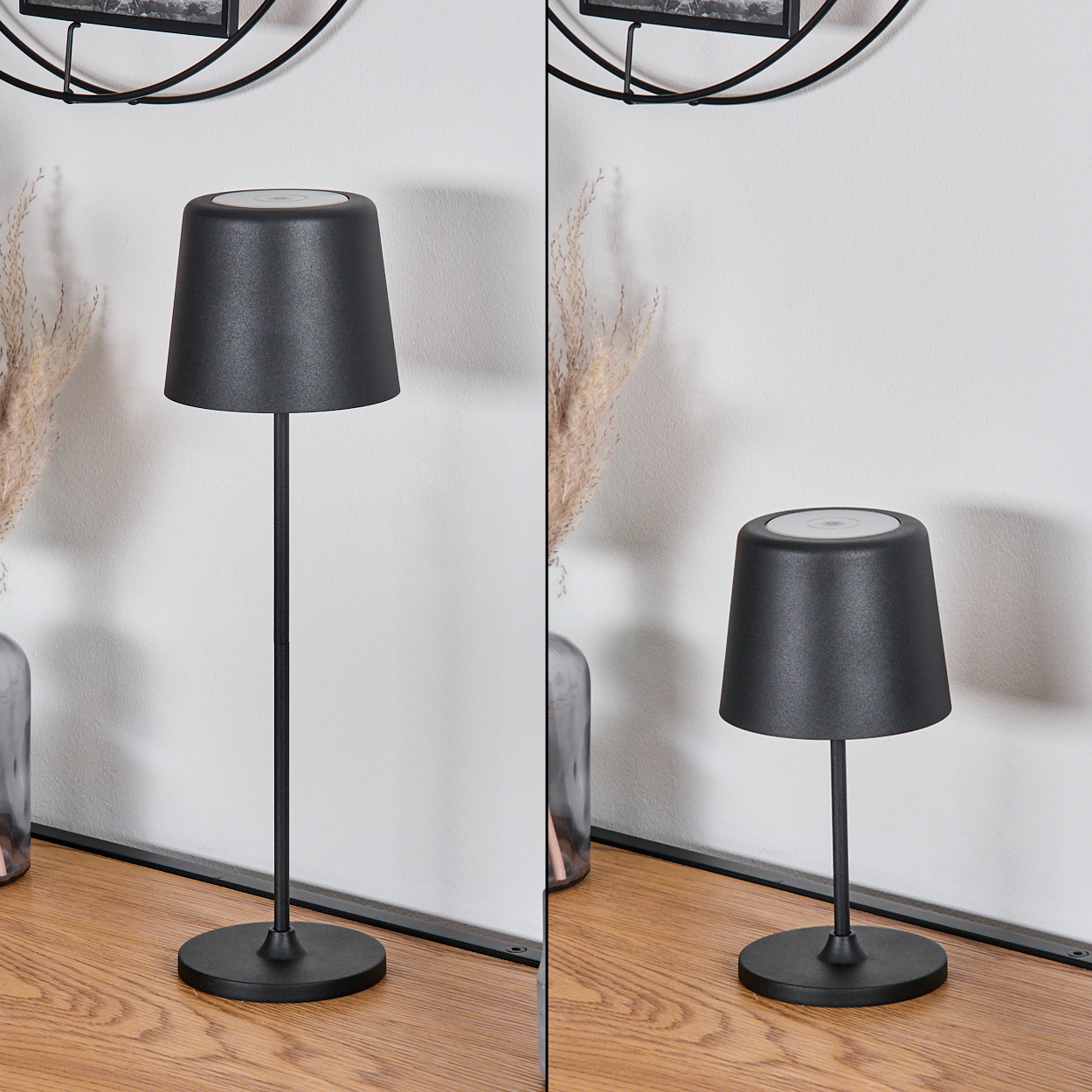Zwei schwarze Lampen auf einer Holzoberfläche. Links eine Vase mit getrockneten Pflanzen. Weiße Wand im Hintergrund.