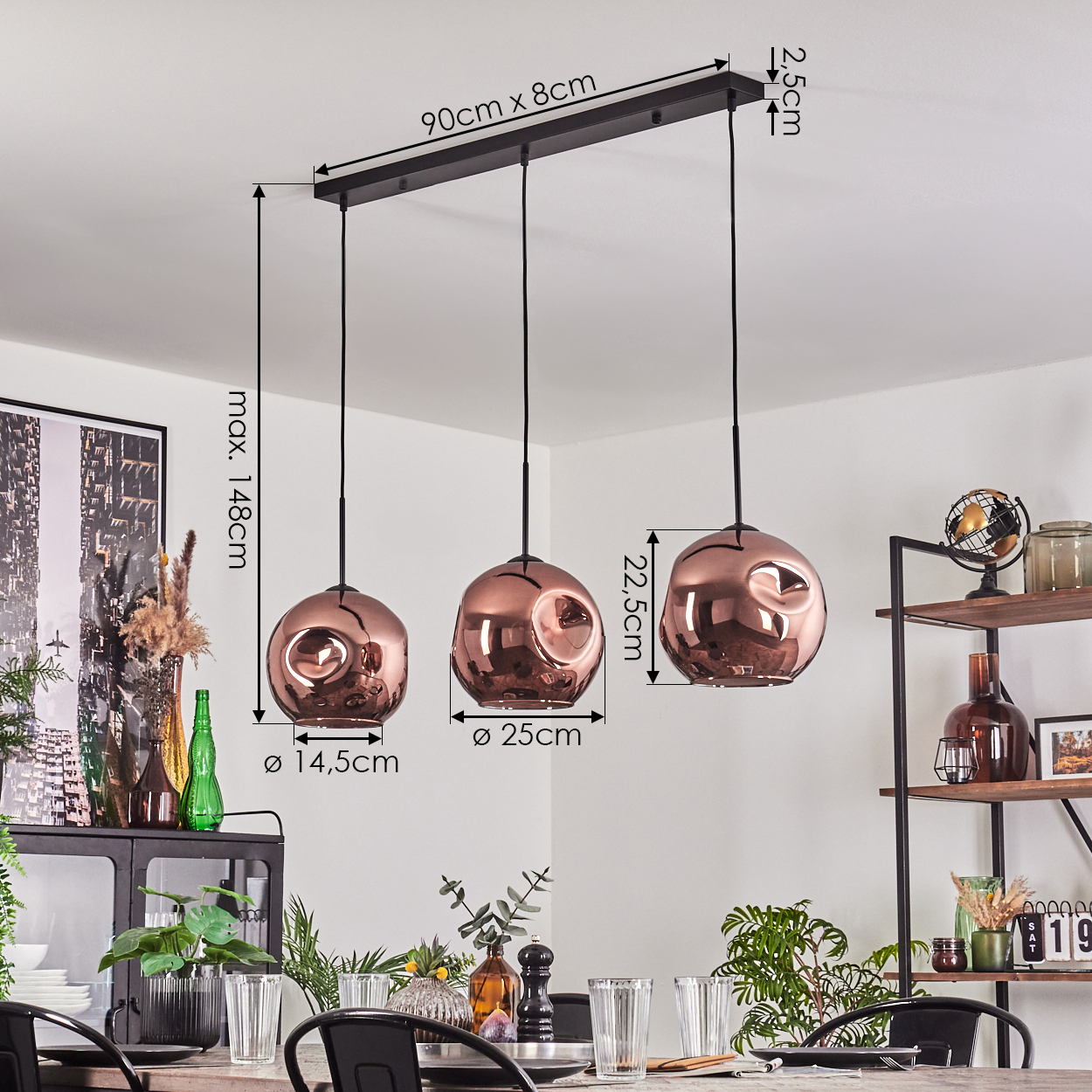 Drei kupferfarbene Pendelleuchten hängen über einem Tisch. Im Hintergrund befindet sich ein Regal mit Dekoration. Abmessungen sind enthalten.