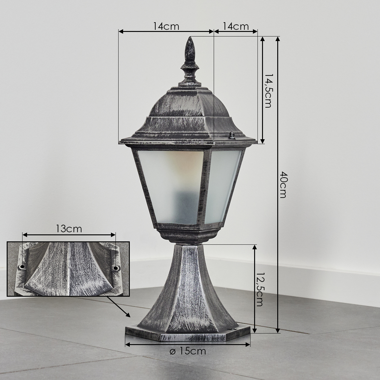 Eine dekorative Außenlampe. Sie hat eine silberne Oberfläche, Milchglas und steht in einer Ecke. Maße sind auf dem Bild angegeben.