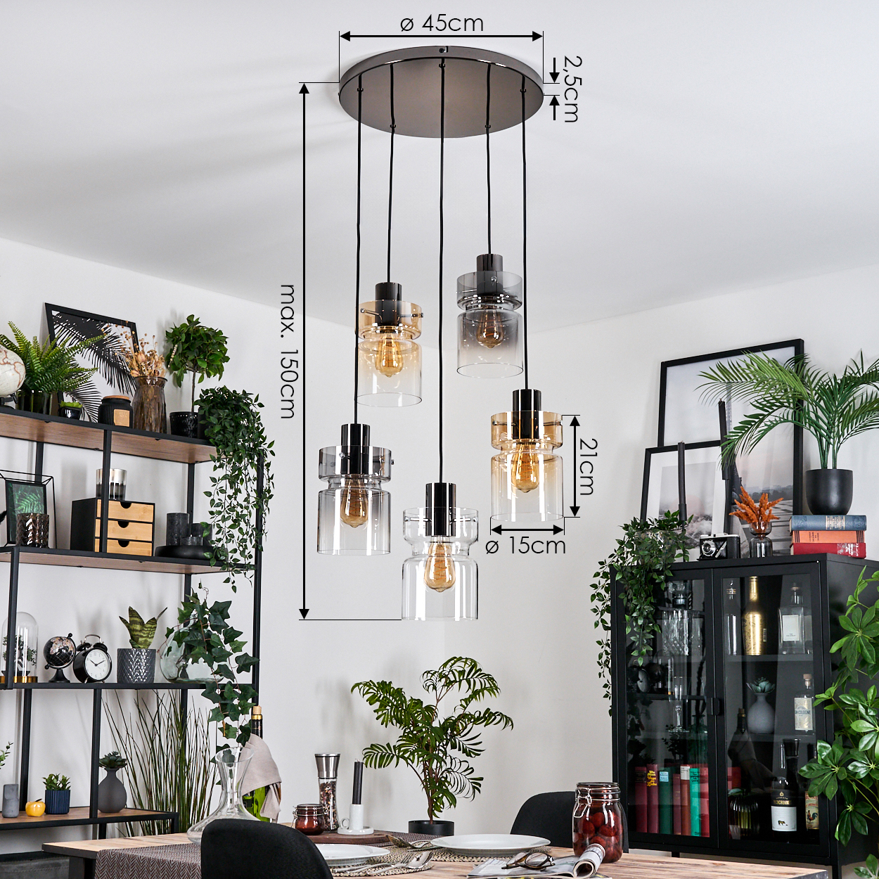 Ein modernes Esszimmer mit Kronleuchter. Pflanzen und Regale im Hintergrund, ein Tisch mit Essen im Vordergrund.