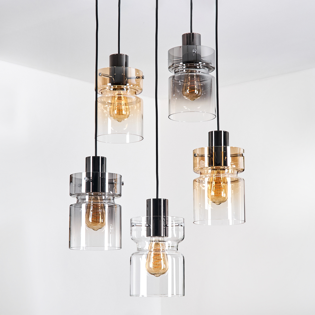 Fünf hängende Pendelleuchten mit Glasschirmen und Edison-Glühbirnen vor weißem Hintergrund.