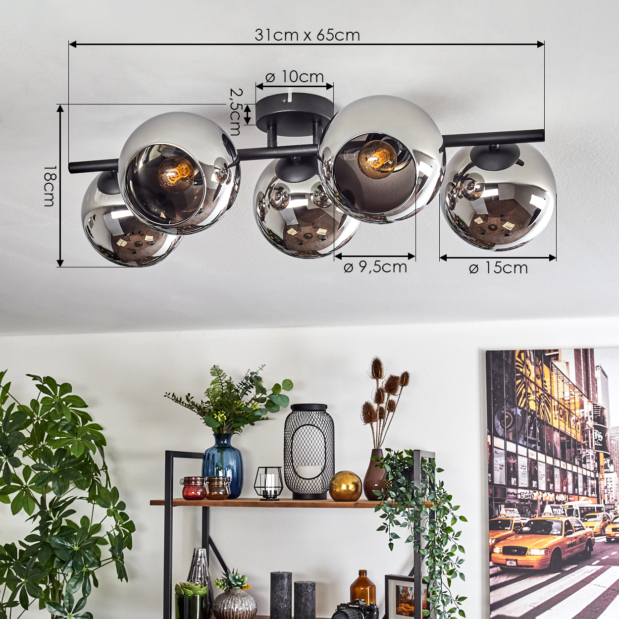 Eine moderne Deckenlampe mit silbernen Kugeln, die den Raum reflektieren. Darunter ein Regal mit Dekorationen und ein Stadtbild.