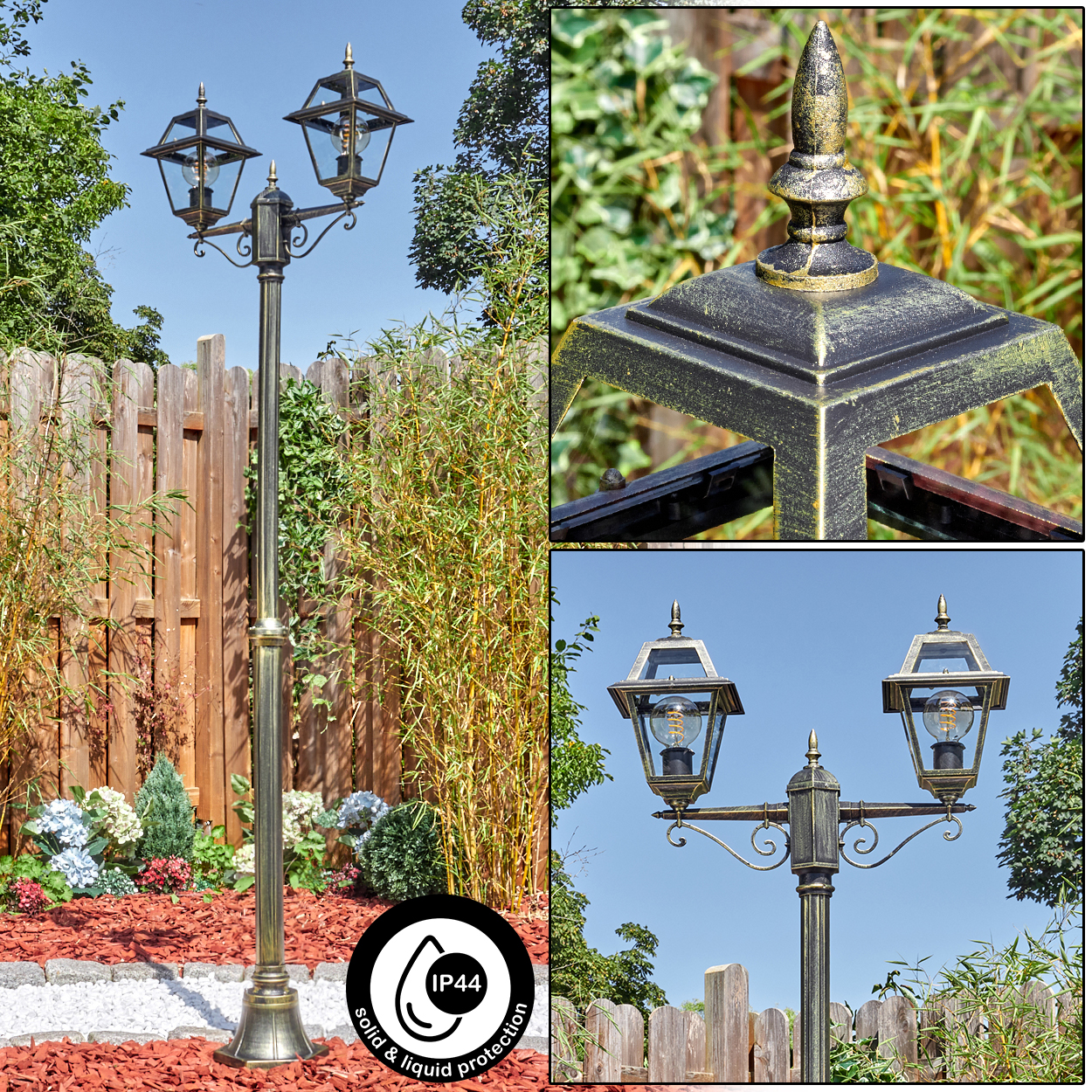 Eine dekorative Außenlampe mit zwei Lichtern, in einem Garten mit Holzzaun und Pflanzen, klarer Himmel im Hintergrund.