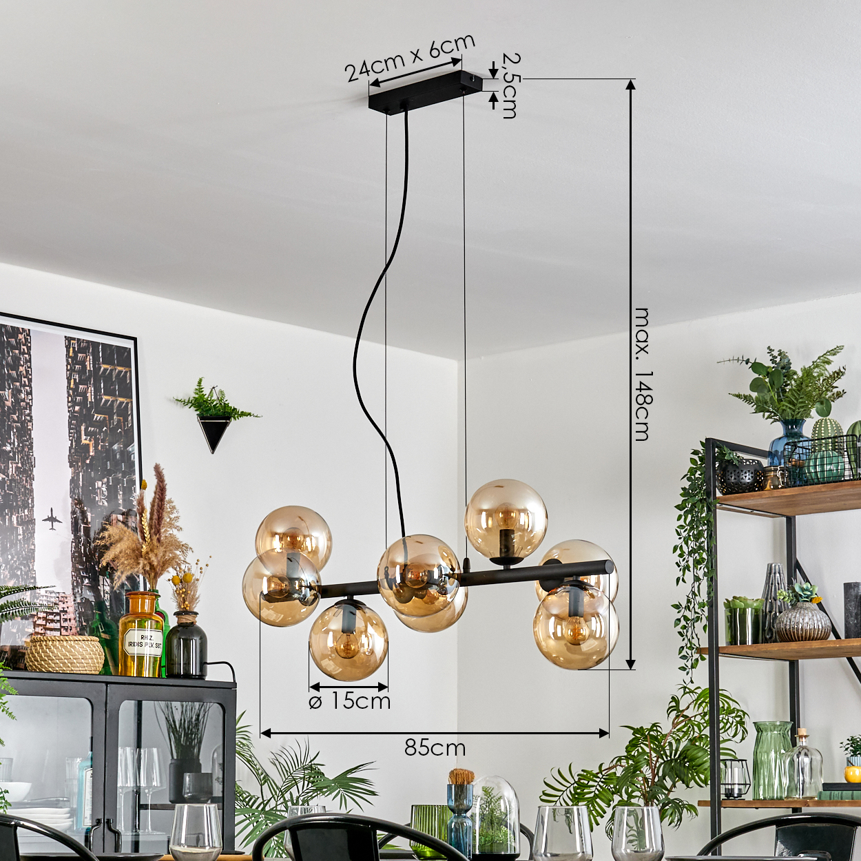 Moderne Esszimmer-Kronleuchter mit Glaskugeln. Maße: 24cm x 6cm, max. 148cm, 85cm. Hintergrund: Pflanzen, Regale und ein Stadtbildfoto.