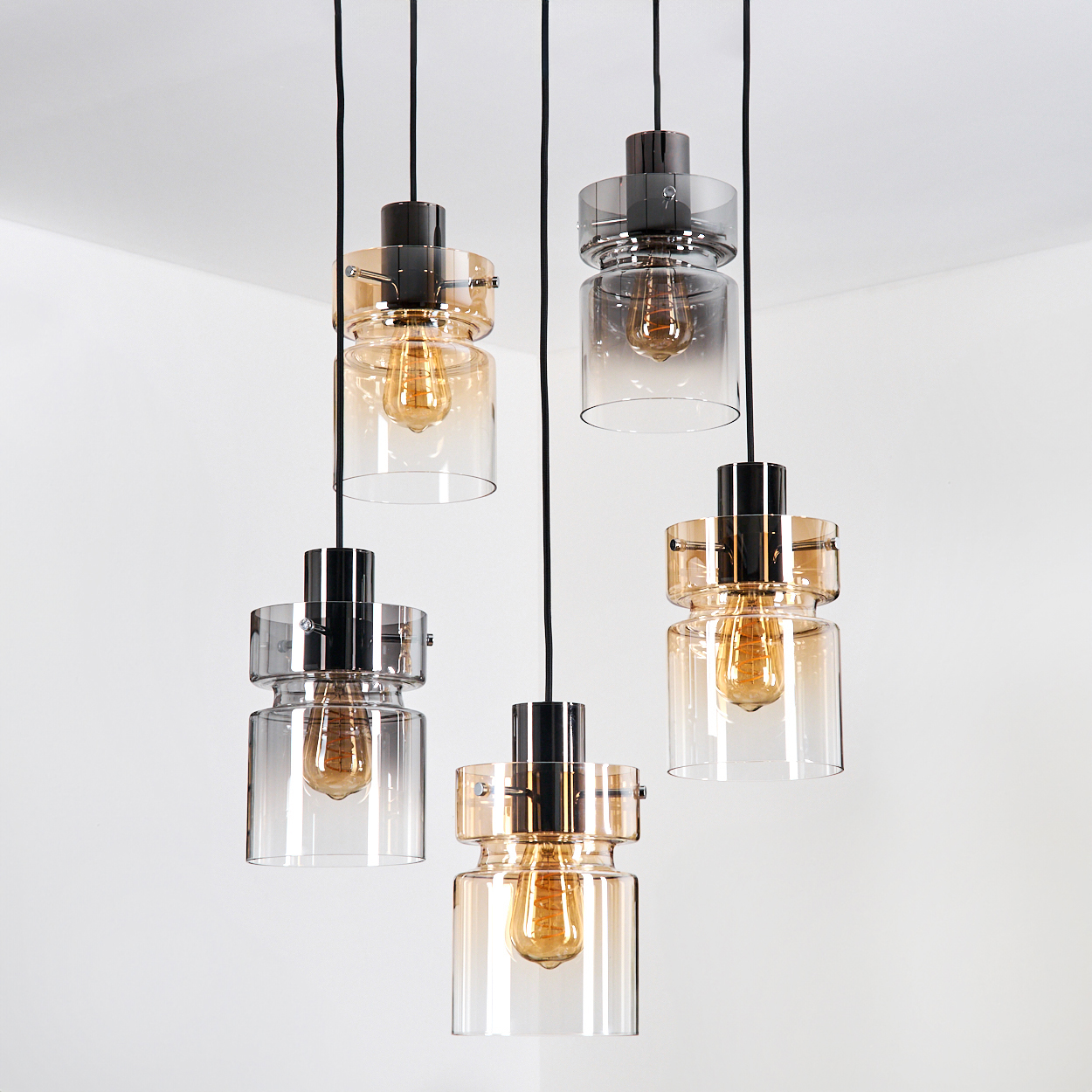 Fünf hängende Pendelleuchten mit Glasschirmen und Edison-Glühbirnen vor weißem Hintergrund.