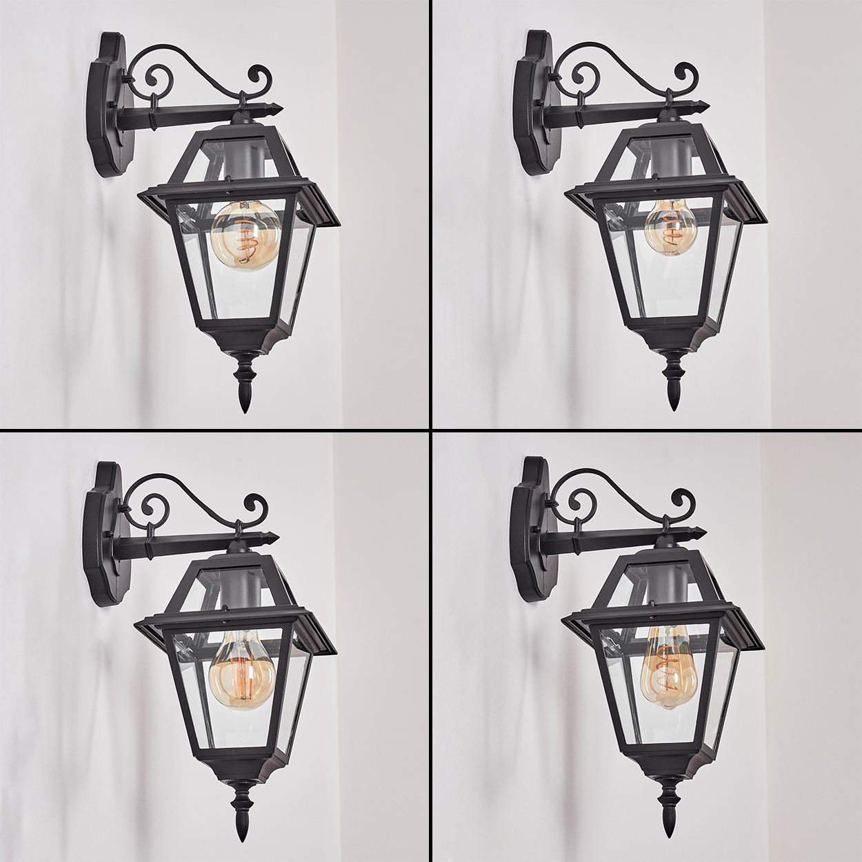 Vier schwarze Außenlampen an einer weißen Wand. Jede hat eine Glühbirne und eine dekorative Halterung. Die Lampen sind identisch.
