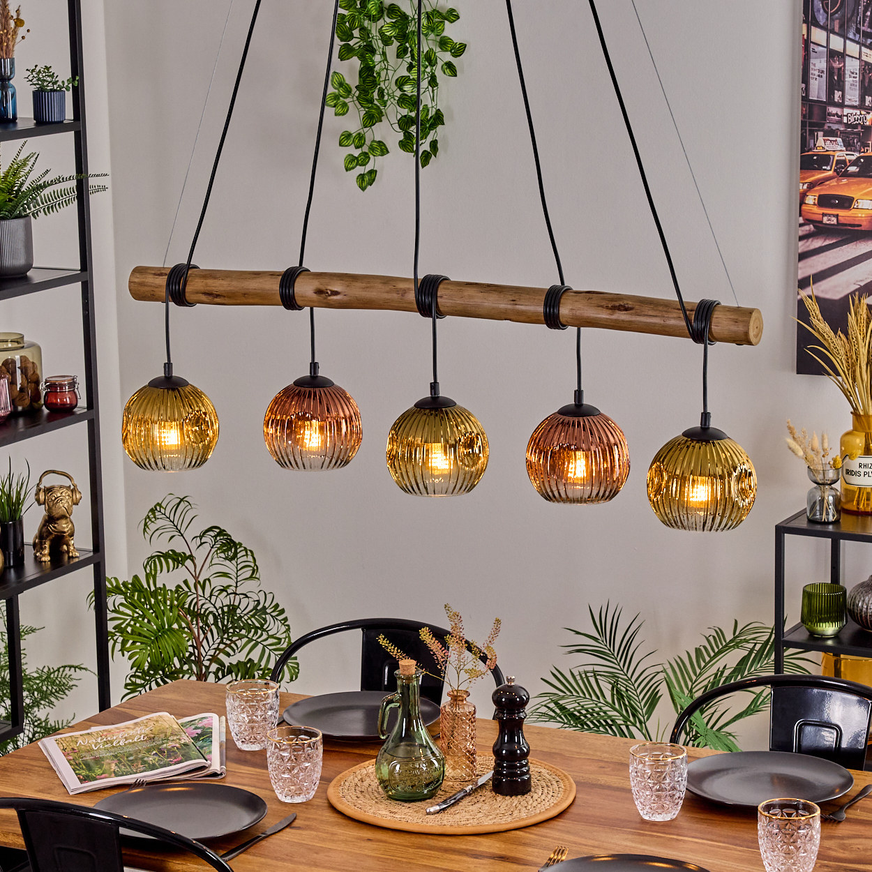Esszimmer mit Holztisch, Hängelampen und Gedecken. Pflanzen und Dekorationen vervollständigen die Szene.