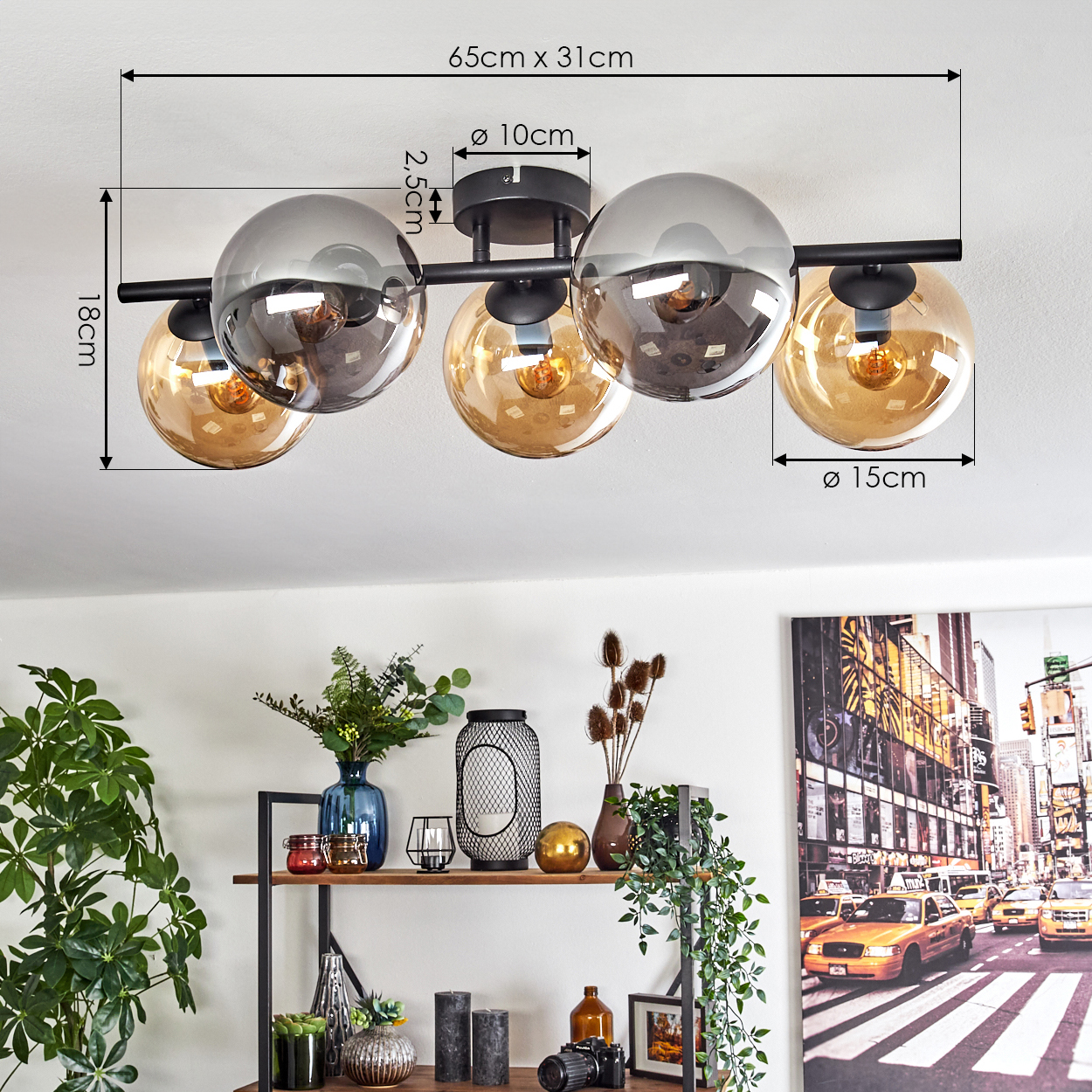 Eine moderne Deckenlampe mit fünf Glaskugeln. Darunter ein Regal mit Dekorationen und ein New York City Bild an der Wand.