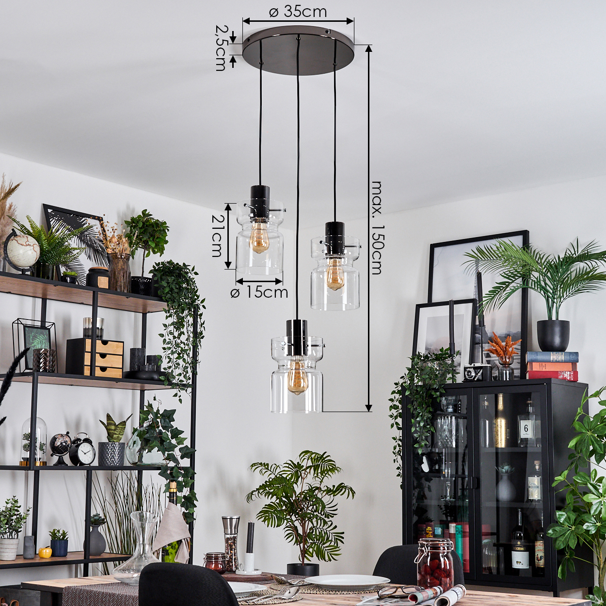 Ein Esszimmer mit Hängelampen, Regalen mit Pflanzen und einem schwarzen Schrank. Ein Tisch ist mit Tellern und Gläsern gedeckt.