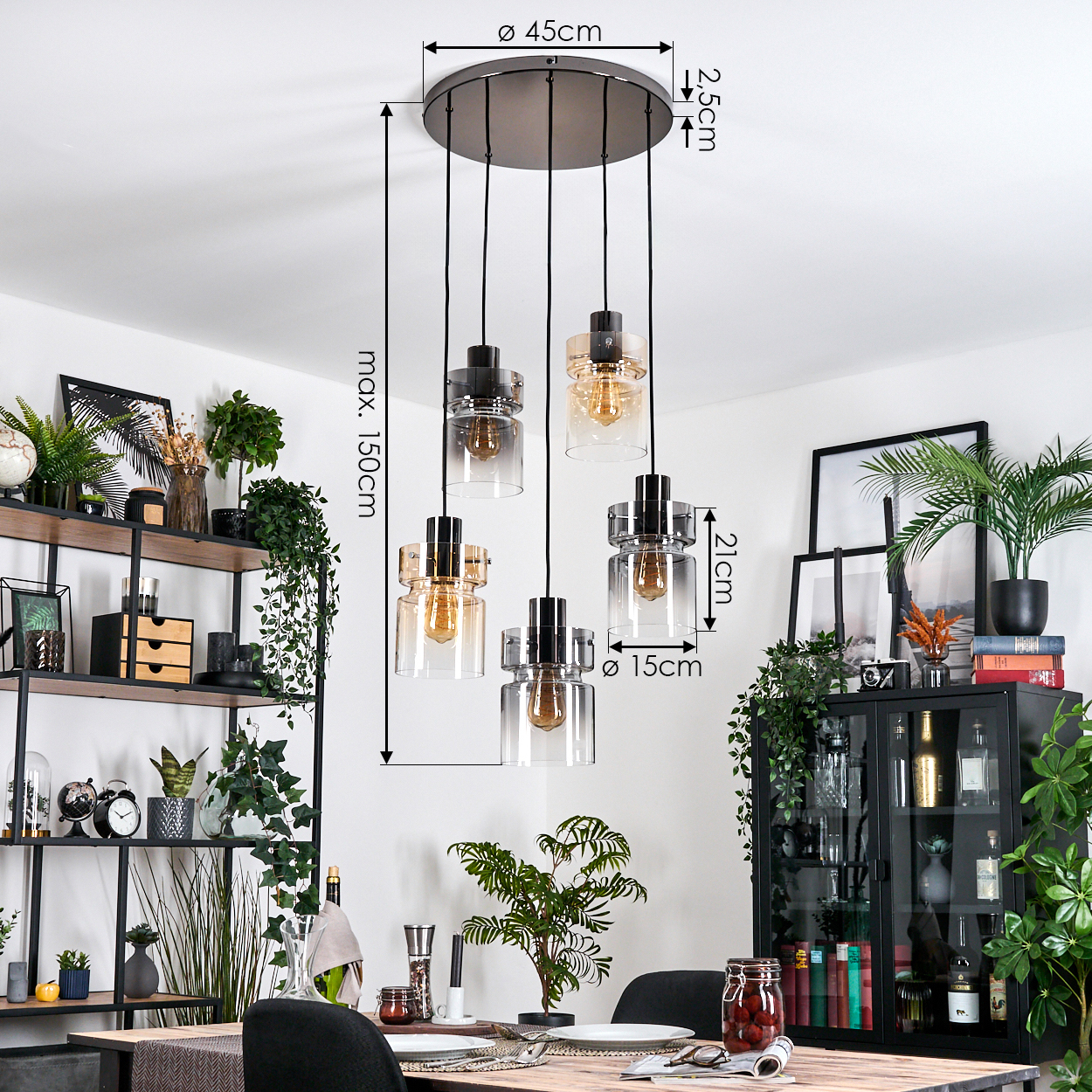 Eine moderne Hängeleuchte mit fünf Glaslampen hängt über einem Holztisch. Regale mit Pflanzen und Dekorationen sind im Hintergrund.