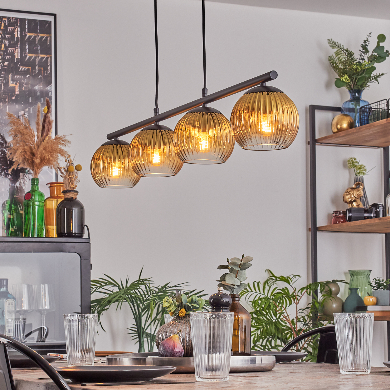Esszimmer mit gedecktem Tisch. Über dem Tisch hängt ein Kronleuchter. Pflanzen und Dekorationen füllen den Raum.