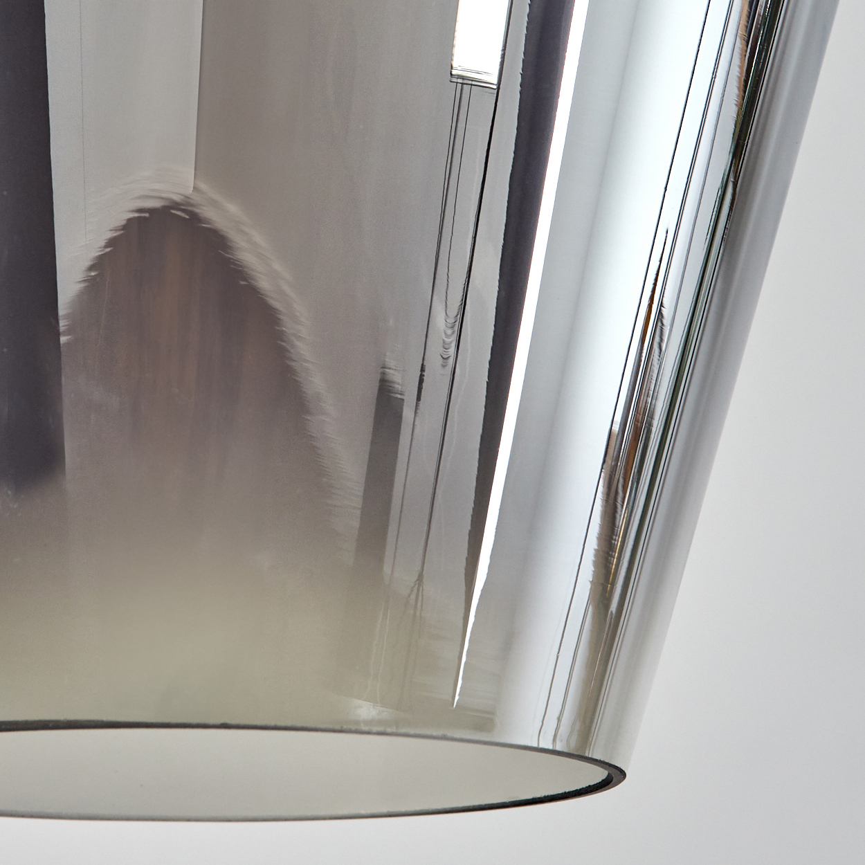 Nahaufnahme eines reflektierenden, zylindrischen Objekts, wahrscheinlich Glas oder Kunststoff. Licht reflektiert sich auf der Oberfläche.