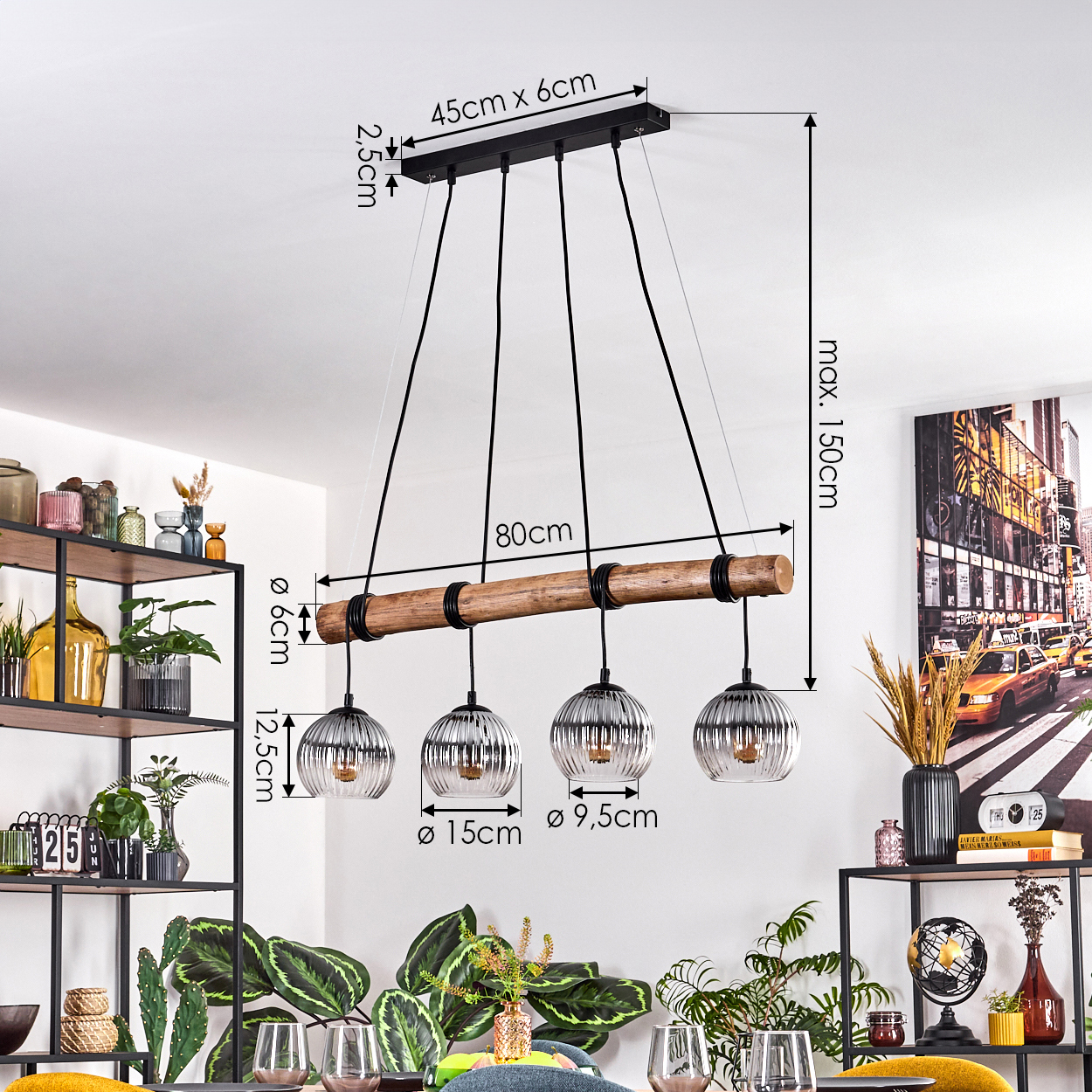 Eine moderne Hängelampe mit vier Glaskugelleuchten hängt über einem Esstisch. Abmessungen sind im Bild vermerkt. Regale und Kunstwerke sind im Hintergrund.