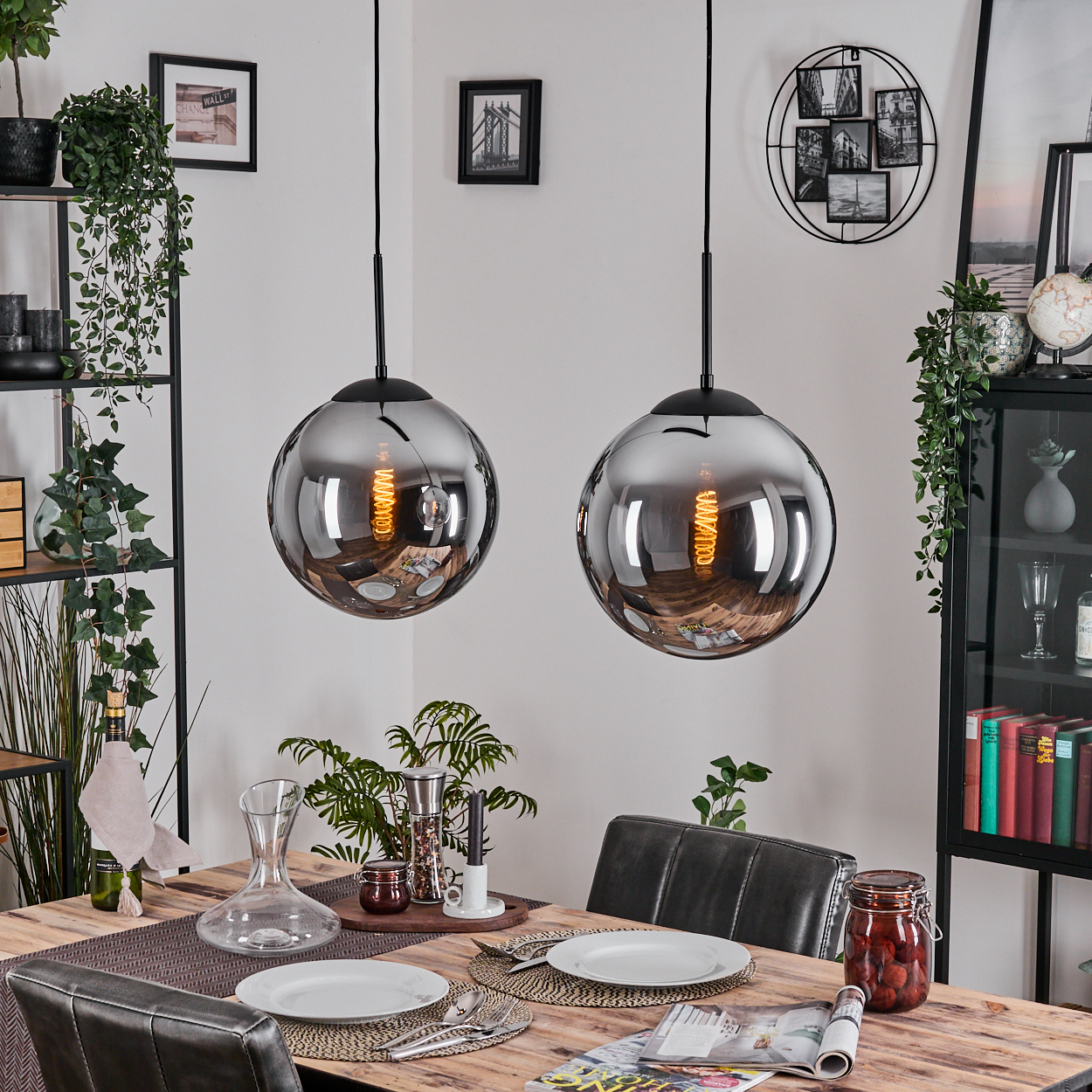 Esszimmer mit zwei hängenden Kugelleuchten, einem Holztisch für das Abendessen und dekorativen Gegenständen.