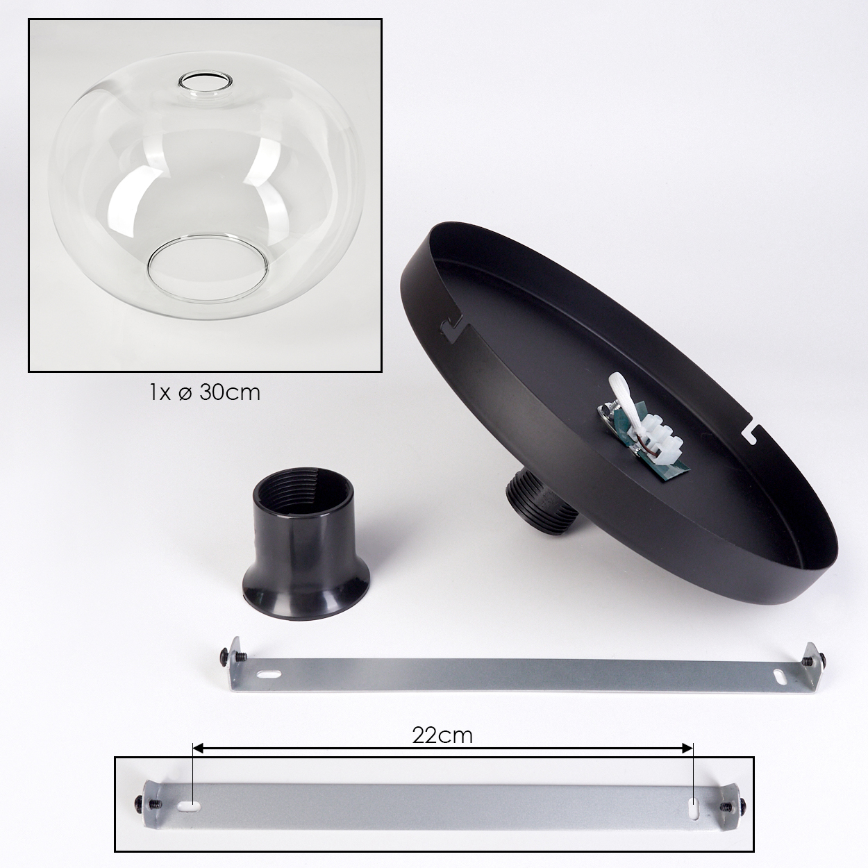 Eine zerlegte Lampe mit einem klaren Glasschirm, schwarzen Metallteilen und einer silbernen Metallhalterung auf weißem Hintergrund.