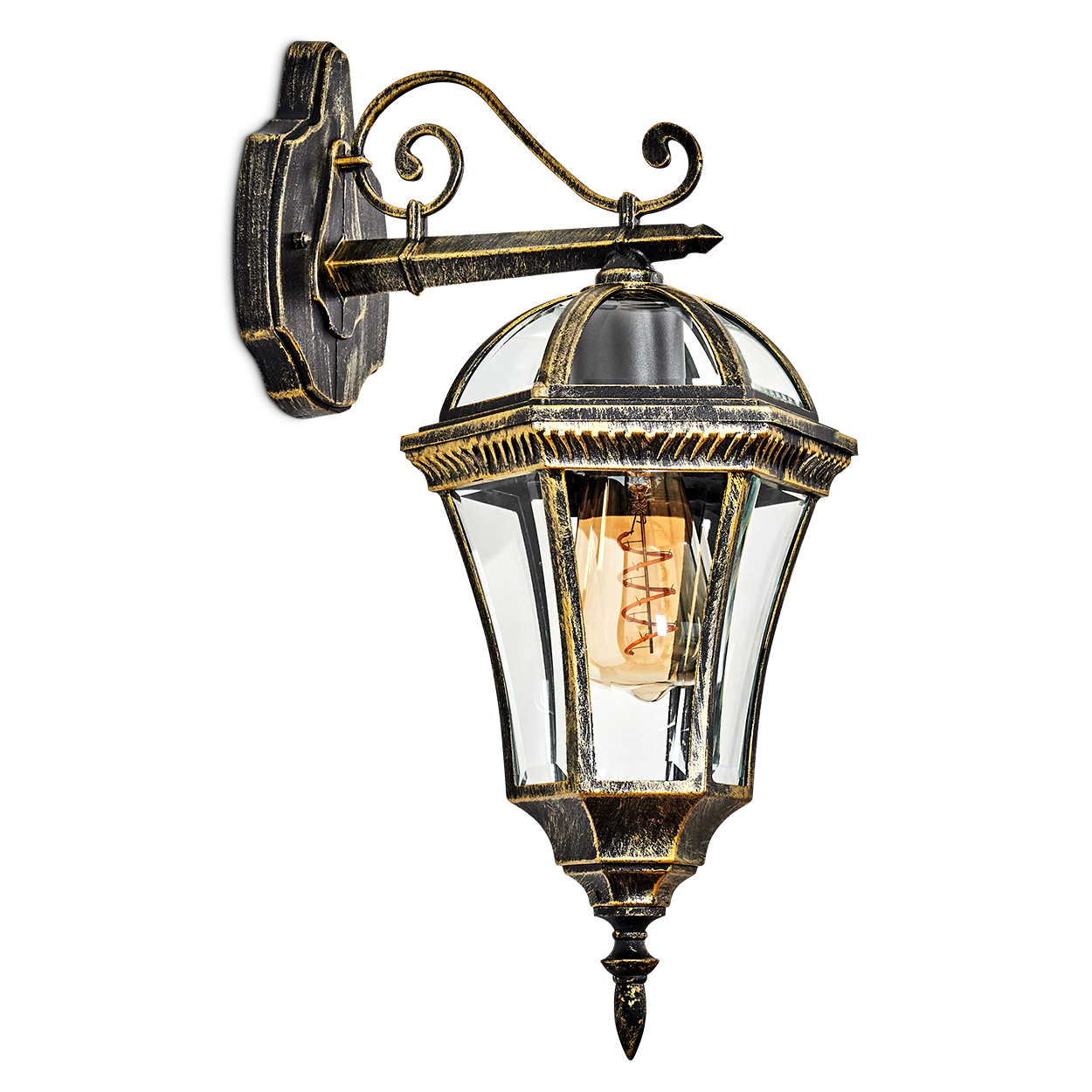 Eine antike Wandlampe mit Glasschirm und Wendelglühbirne. Sie ist gold und schwarz und an einer weißen Wand montiert.