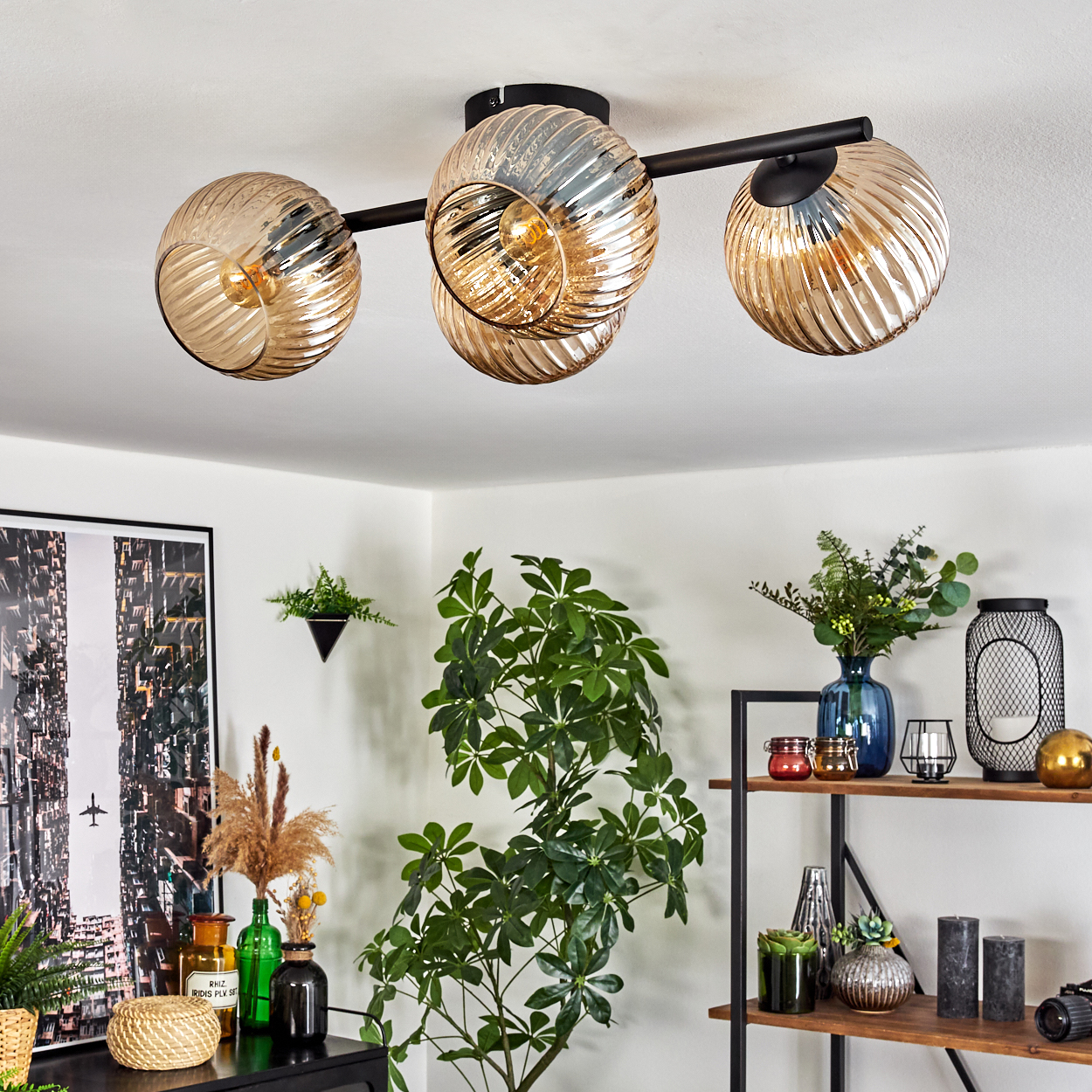 Deckenleuchte mit Glaskugeln, Pflanzen und Regalen. Der Raum hat ein modernes Design mit Kunst an der Wand und verschiedenen Dekorationsartikeln.