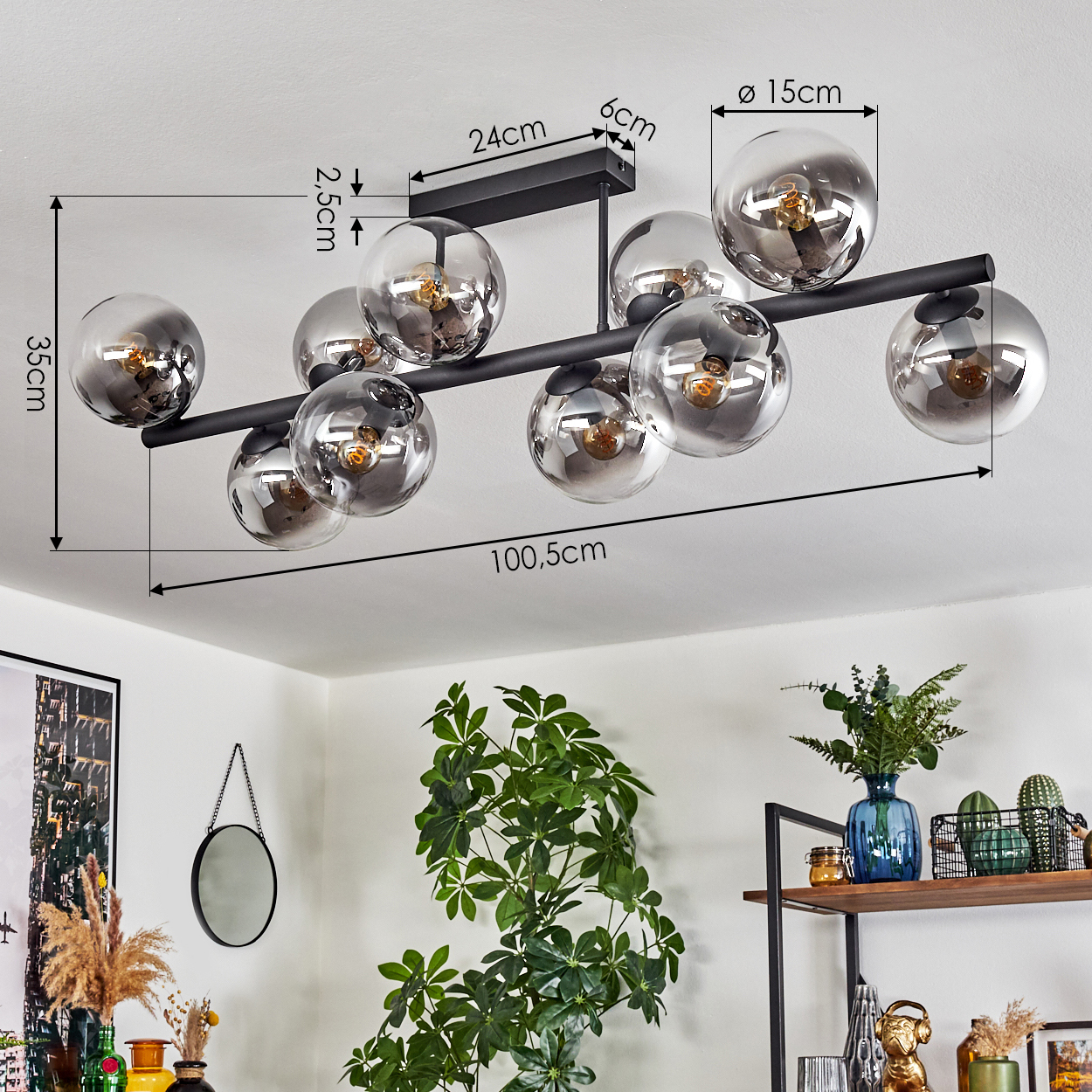 Eine moderne Deckenlampe mit zehn Glaskugeln. Maße sind angegeben. Ein Raum mit Pflanzen, einem Spiegel und Regalen mit Dekor.