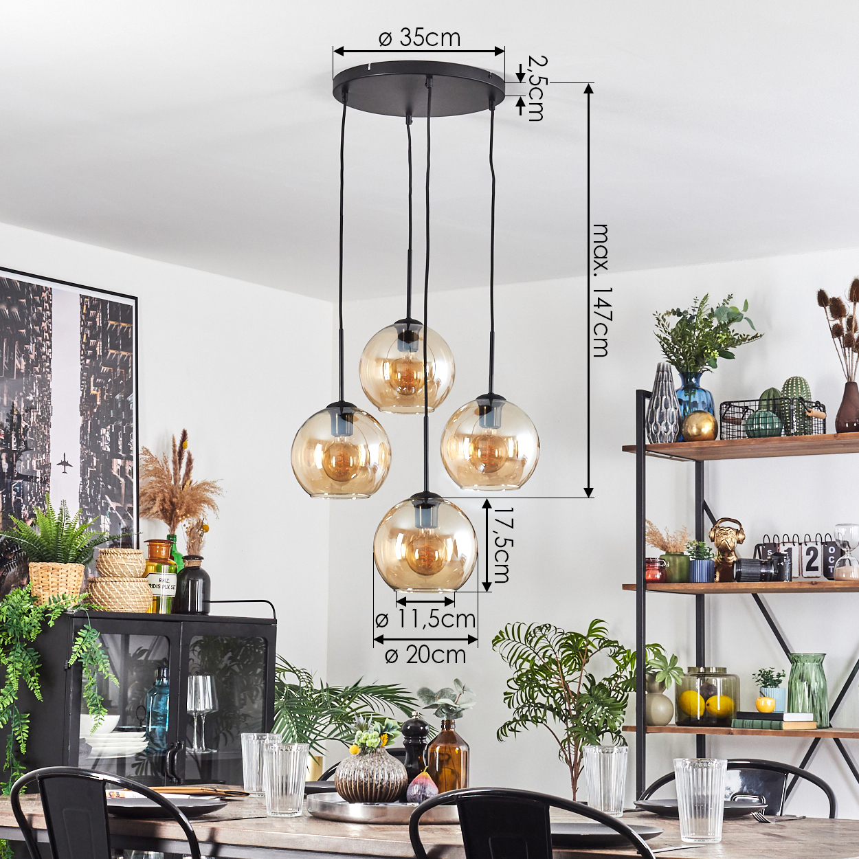 Esszimmer mit einer Hängelampe mit vier bernsteinfarbenen Glasschirmen. Ein Tisch ist mit Gläsern und Pflanzen gedeckt. Regale sind sichtbar.