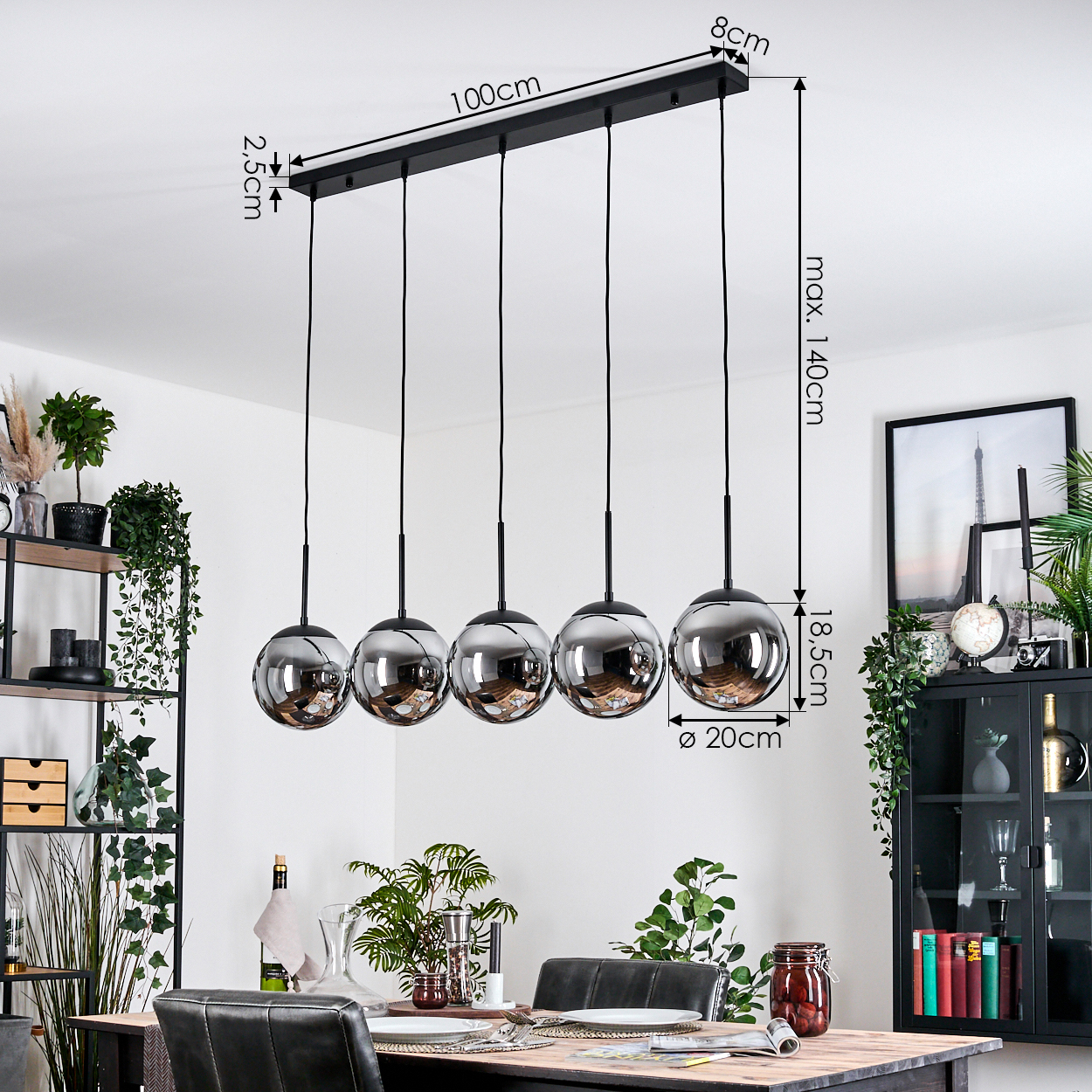 Ein Esszimmer mit einem schwarzen Kronleuchter mit fünf kugelförmigen Lichtern. Der Tisch ist mit Tellern und Gläsern gedeckt.
