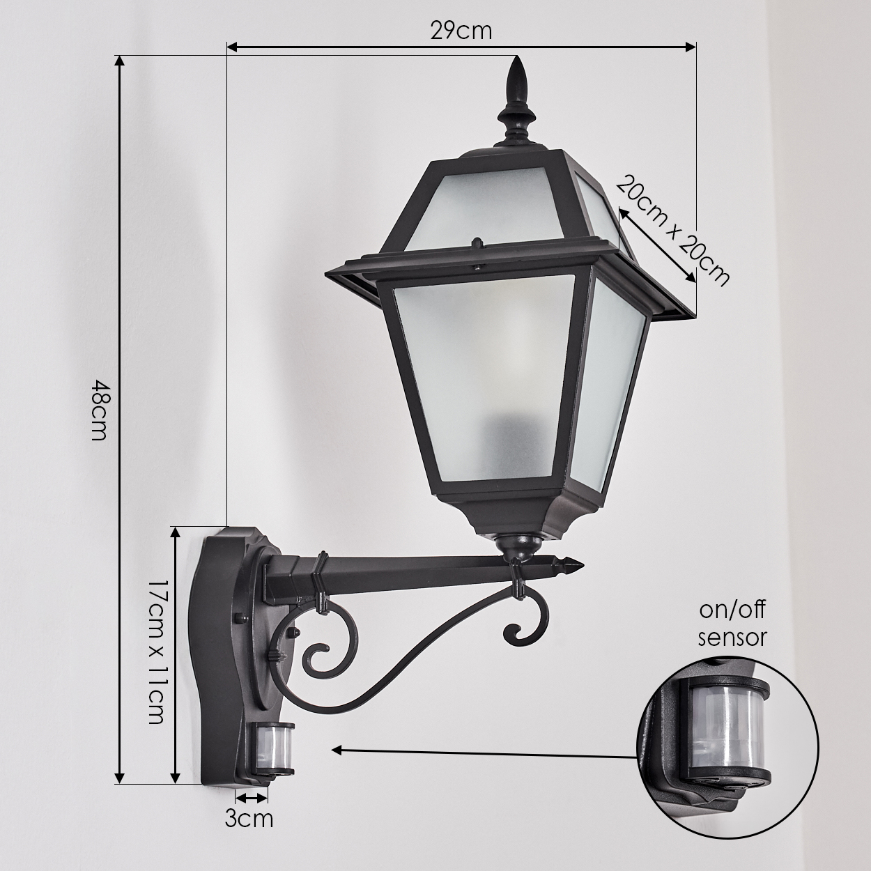 Schwarze Außenlampe an einer weißen Wand. Abmessungen sind angegeben. Enthält einen Ein/Aus-Sensor.