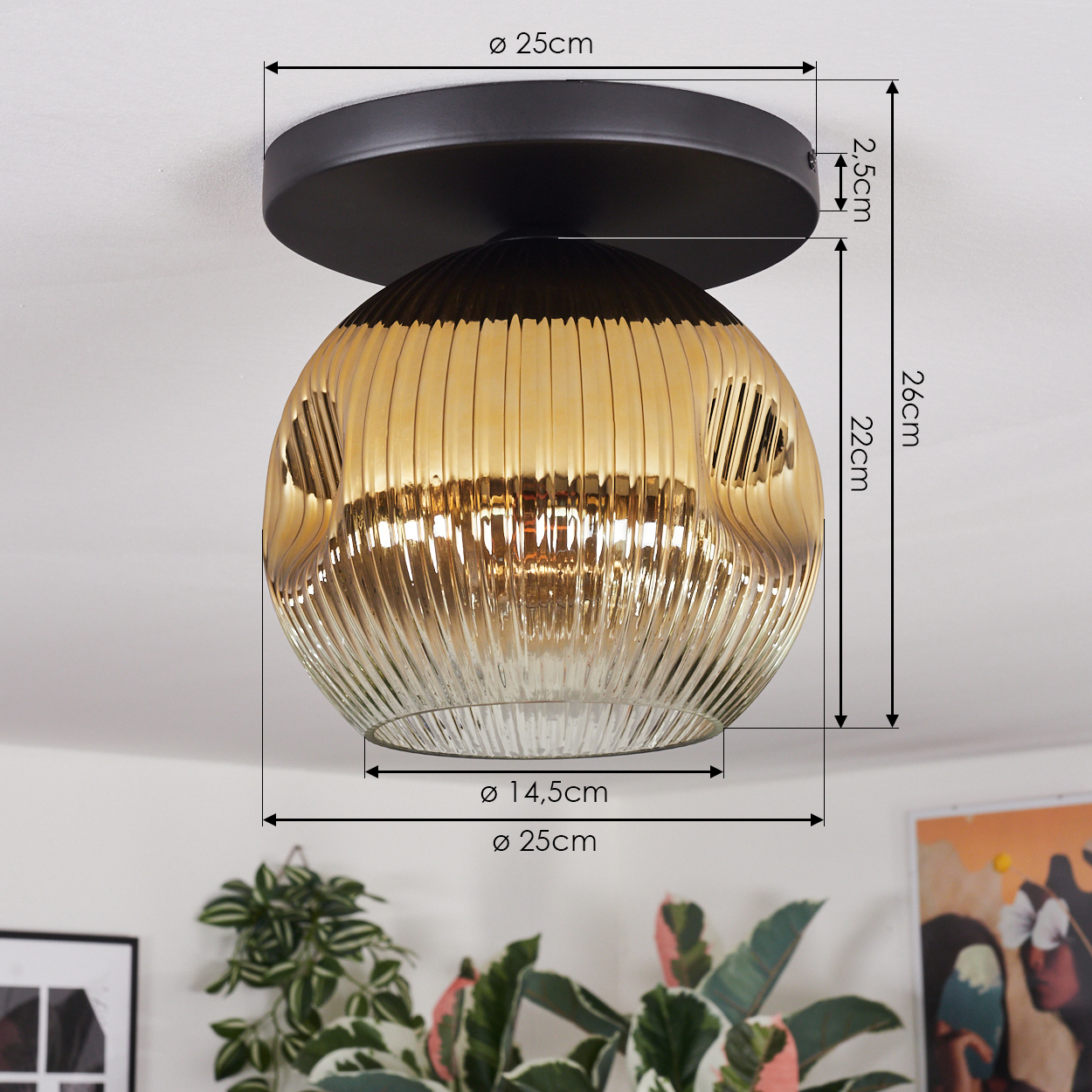 Eine goldene Deckenlampe aus geripptem Glas mit schwarzem Sockel. Maße sind beschriftet. Pflanzen und gerahmte Kunst im Vordergrund.