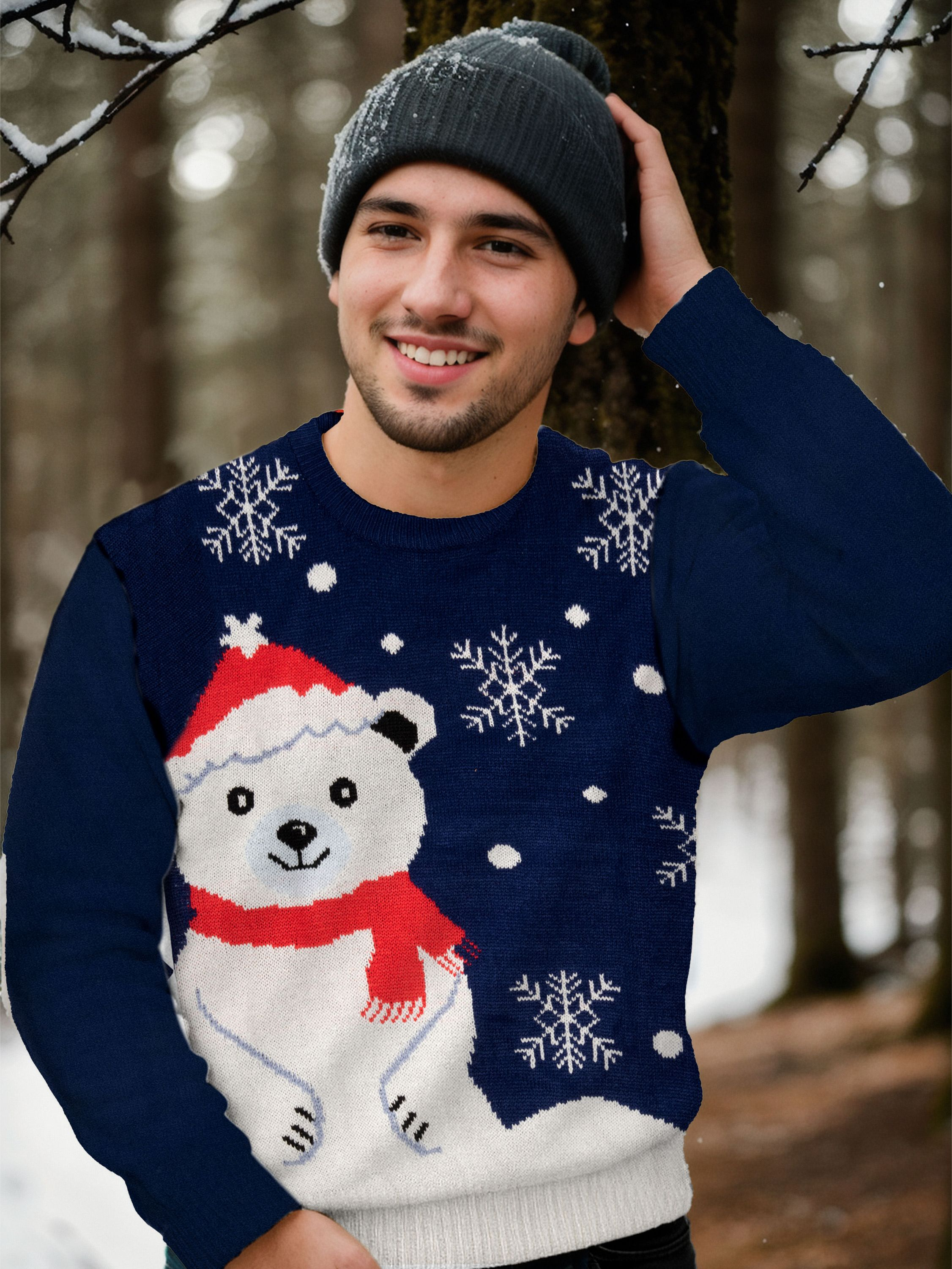 Ein Mann in einem Winterpullover mit Bärenmuster lächelt in einem verschneiten Wald und trägt eine Mütze.