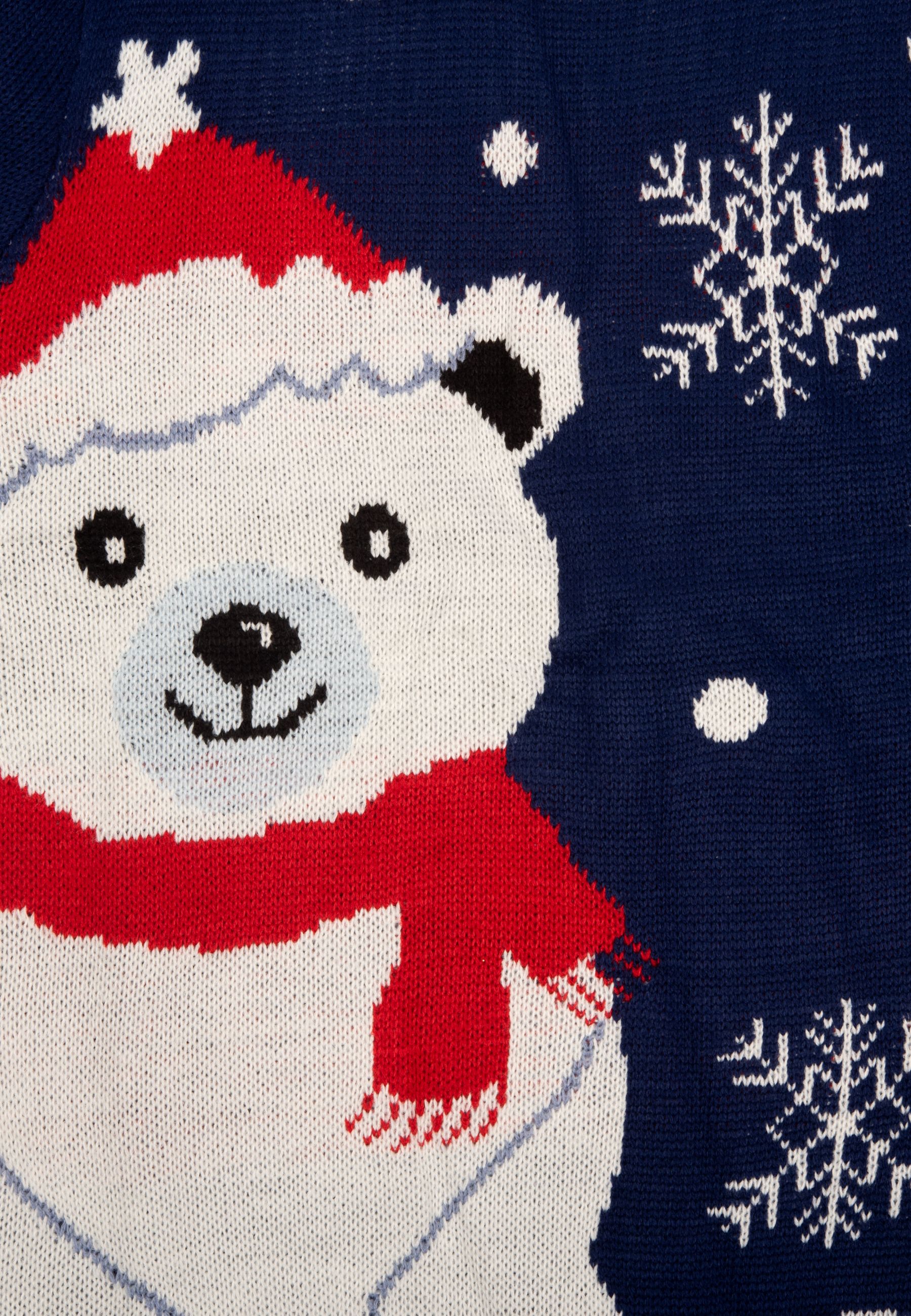 Nahaufnahme eines blauen Strickpullovers mit einem Eisbären, der einen Weihnachtsmannhut und einen Schal trägt, mit Schneeflocken.