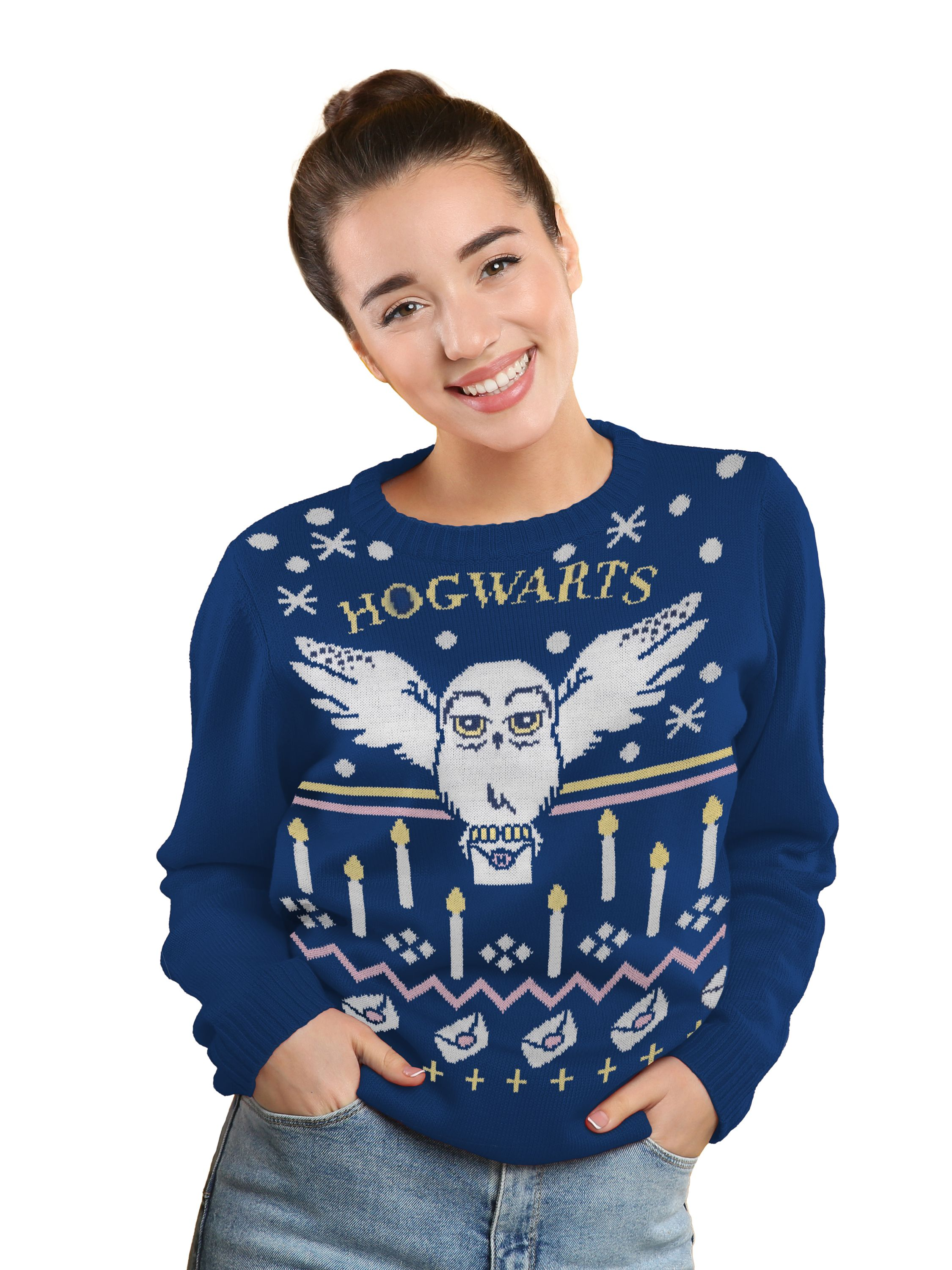Lächelnde Frau in blauem Hogwarts-Pullover mit Händen in den Taschen. Weißer Hintergrund.