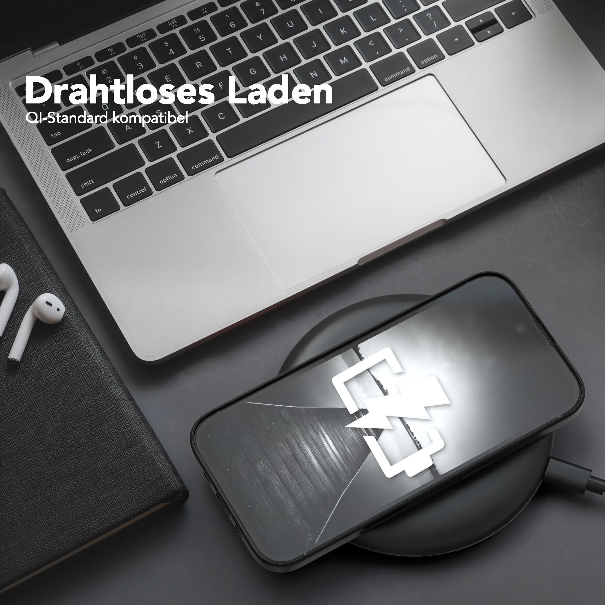 Ein Telefon auf einem kabellosen Ladegerät, neben einem Laptop und Ohrhörern. Das Telefon zeigt ein Ladesymbol.