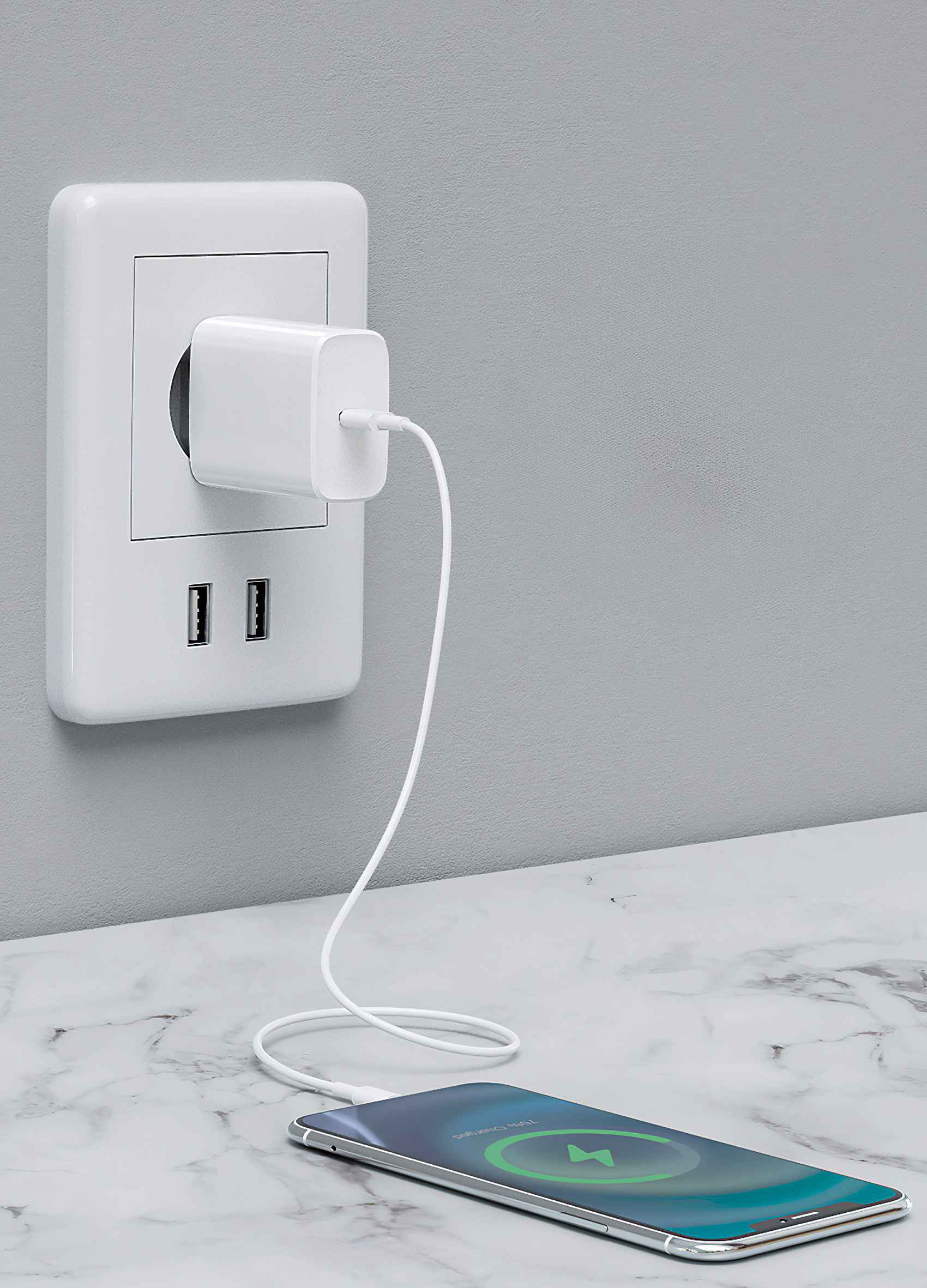 Ein weißes Ladegerät ist in eine Steckdose gesteckt, mit Kabel an ein Handy auf Marmor.