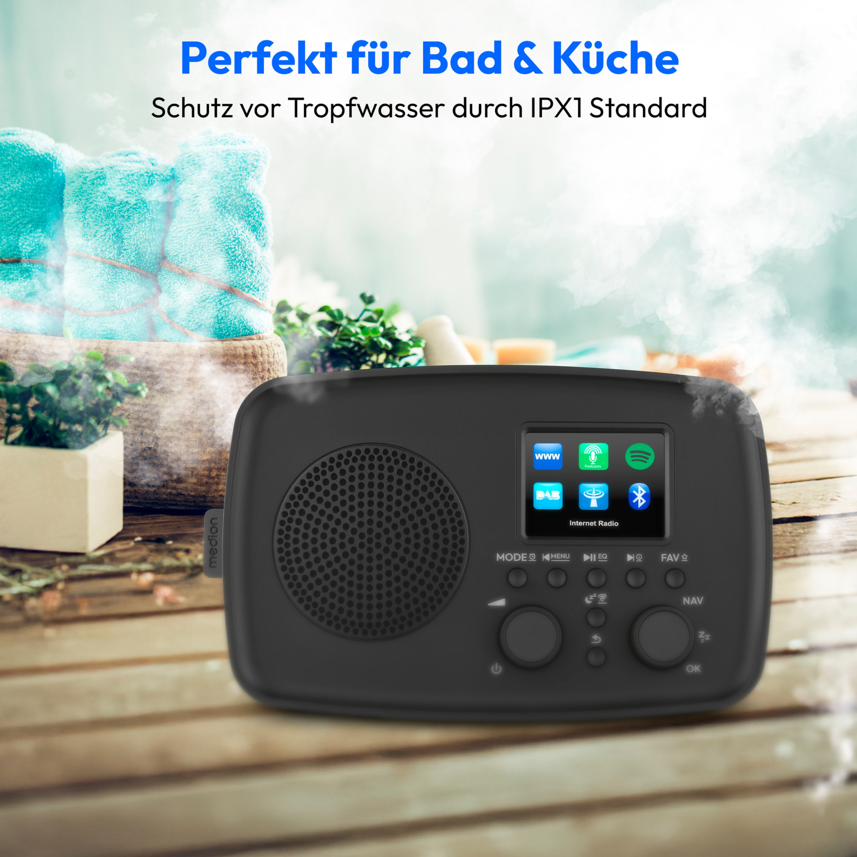 Ein schwarzes Radio mit Bildschirm liegt auf Holz. Blaue Handtücher und Text auf Deutsch sind im Hintergrund.