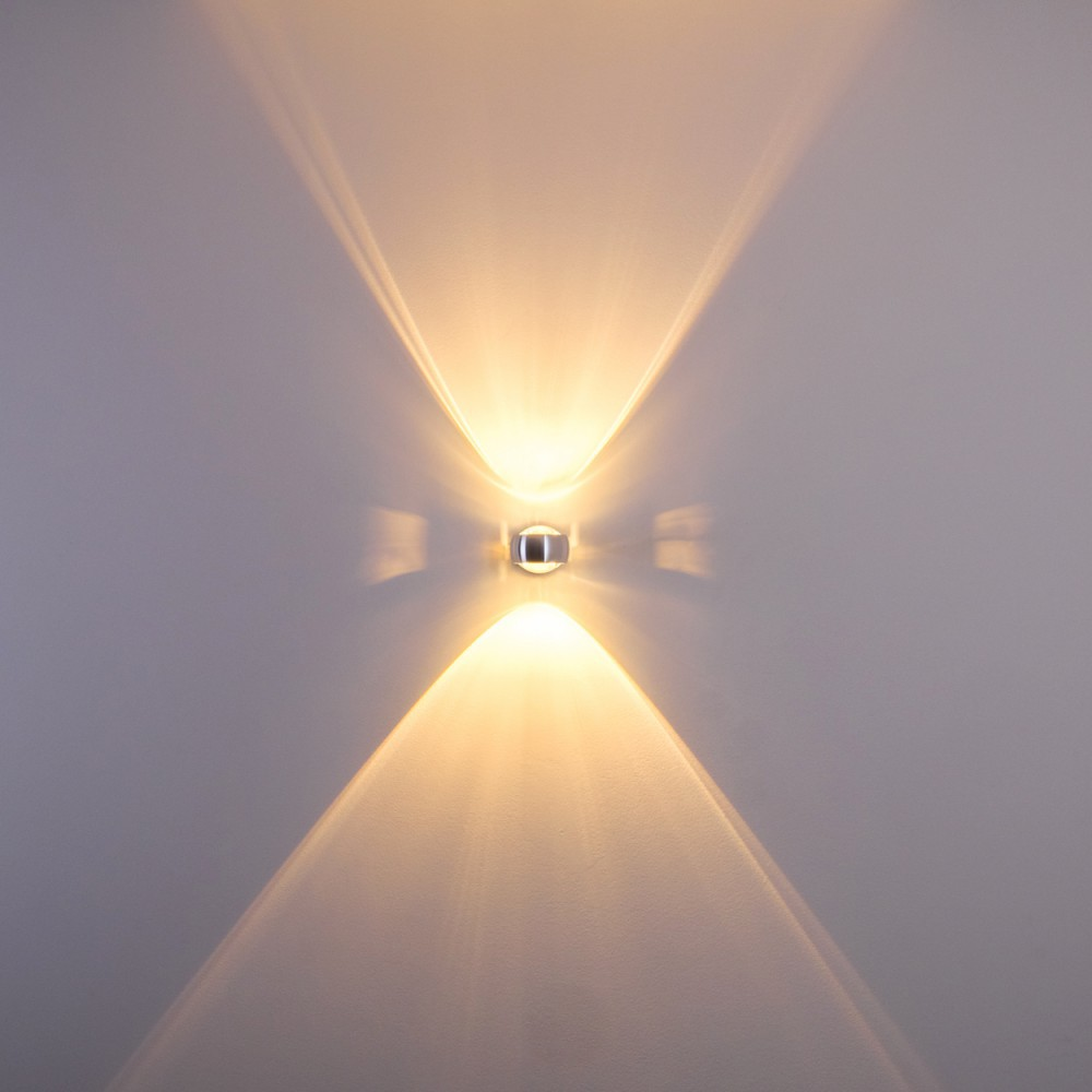 Eine Wandleuchte strahlt Licht in zwei entgegengesetzte Richtungen aus. Das Licht ist fokussiert und erzeugt ein symmetrisches Muster.