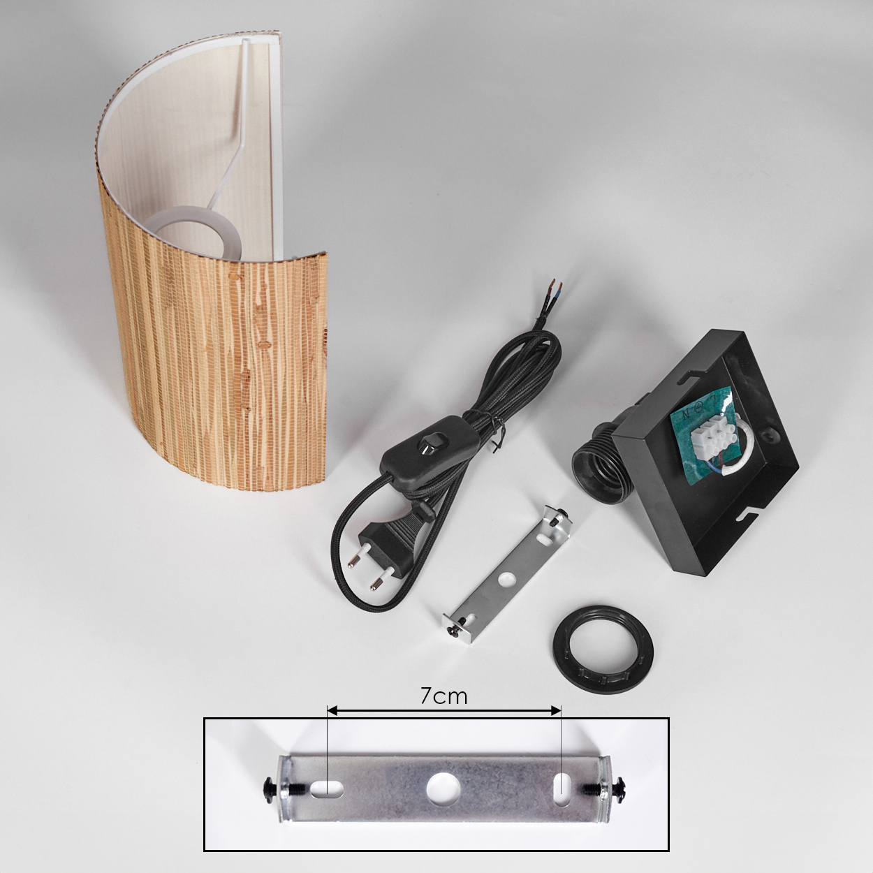 Eine zerlegte Lampe mit Bambus-Lampenschirm, elektrischen Komponenten und einer Metallhalterung auf weißer Oberfläche. Eine 7 cm Halterung ist abgebildet.
