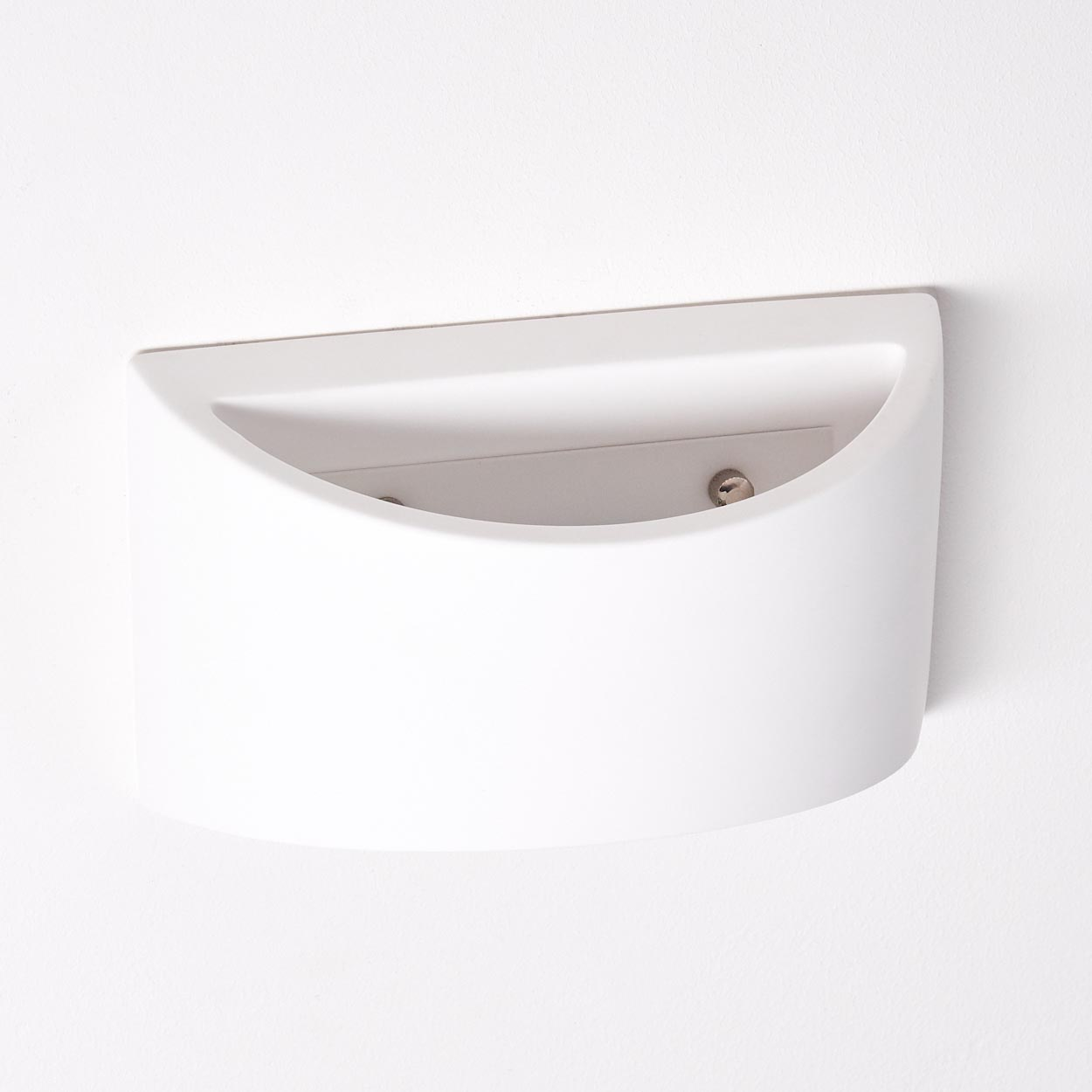 Ein weißer, halbkreisförmiger Wandpflanzer. Er ist an einer weißen Wand befestigt. Der Pflanzer hat ein glattes, geschwungenes Design und ist leer.