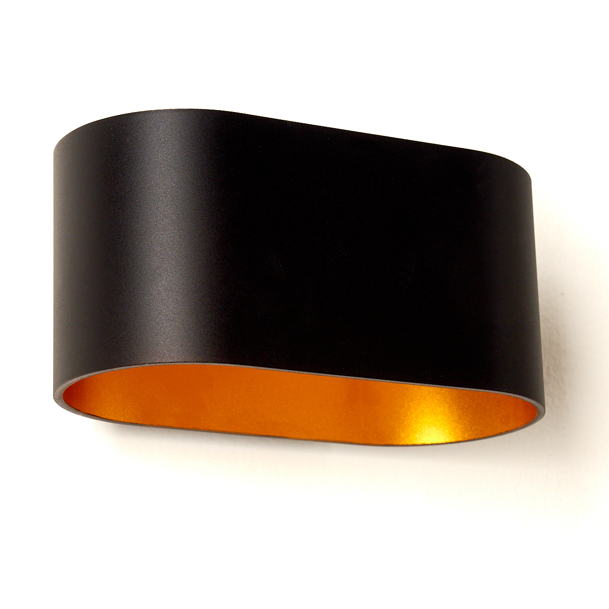 Eine moderne Wandlampe. Sie ist außen schwarz und innen goldfarben. Die Lampe ist an einer weißen Wand befestigt.