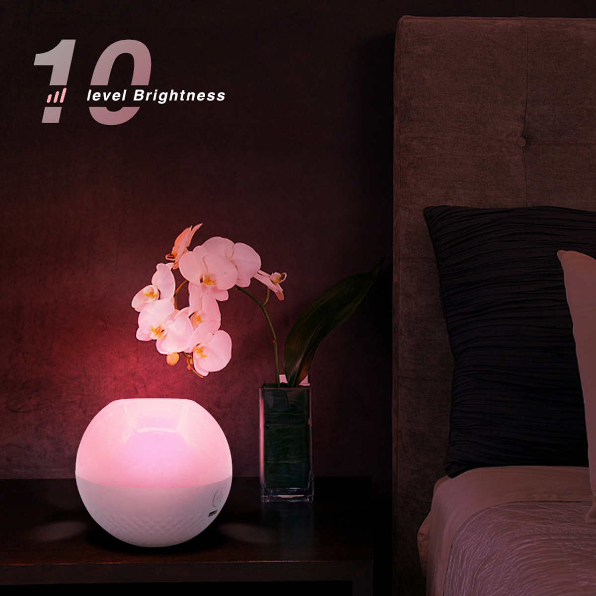 Ein Nachttisch mit einer leuchtenden Lampe, Orchideen in einer Vase und einem Bett. Das Licht der Lampe beleuchtet die Blumen.