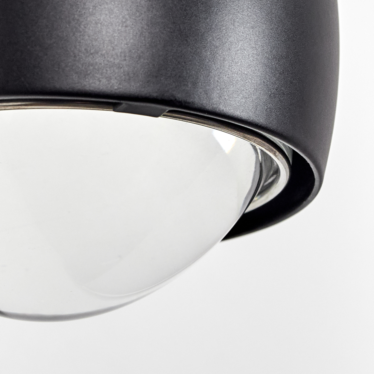 Nahaufnahme eines schwarzen Lampenschirms mit Glaskuppel auf weißem Hintergrund.