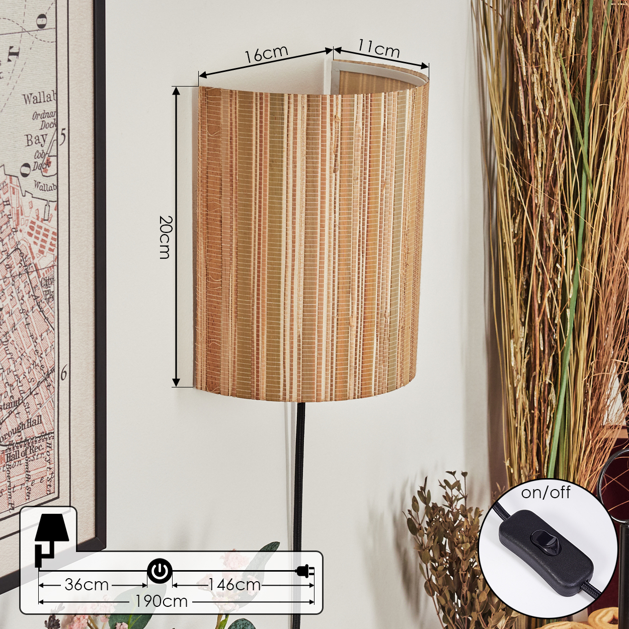Eine Wandlampe mit gewebtem Schirm ist an einer weißen Wand befestigt. Daneben eine Karte und getrocknete Pflanzen. Ein Ein-/Ausschalter ist sichtbar.