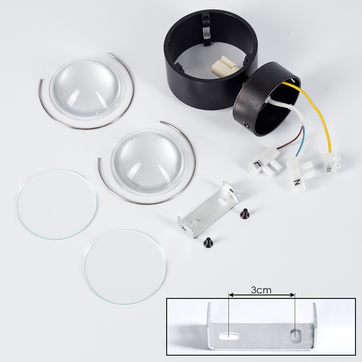 Zerlegte LED-Lichtkomponenten. Enthält Linsen, Metallhalterung, Drähte und ein schwarzes kreisförmiges Gehäuse. Klare und weiße Farben dominieren.