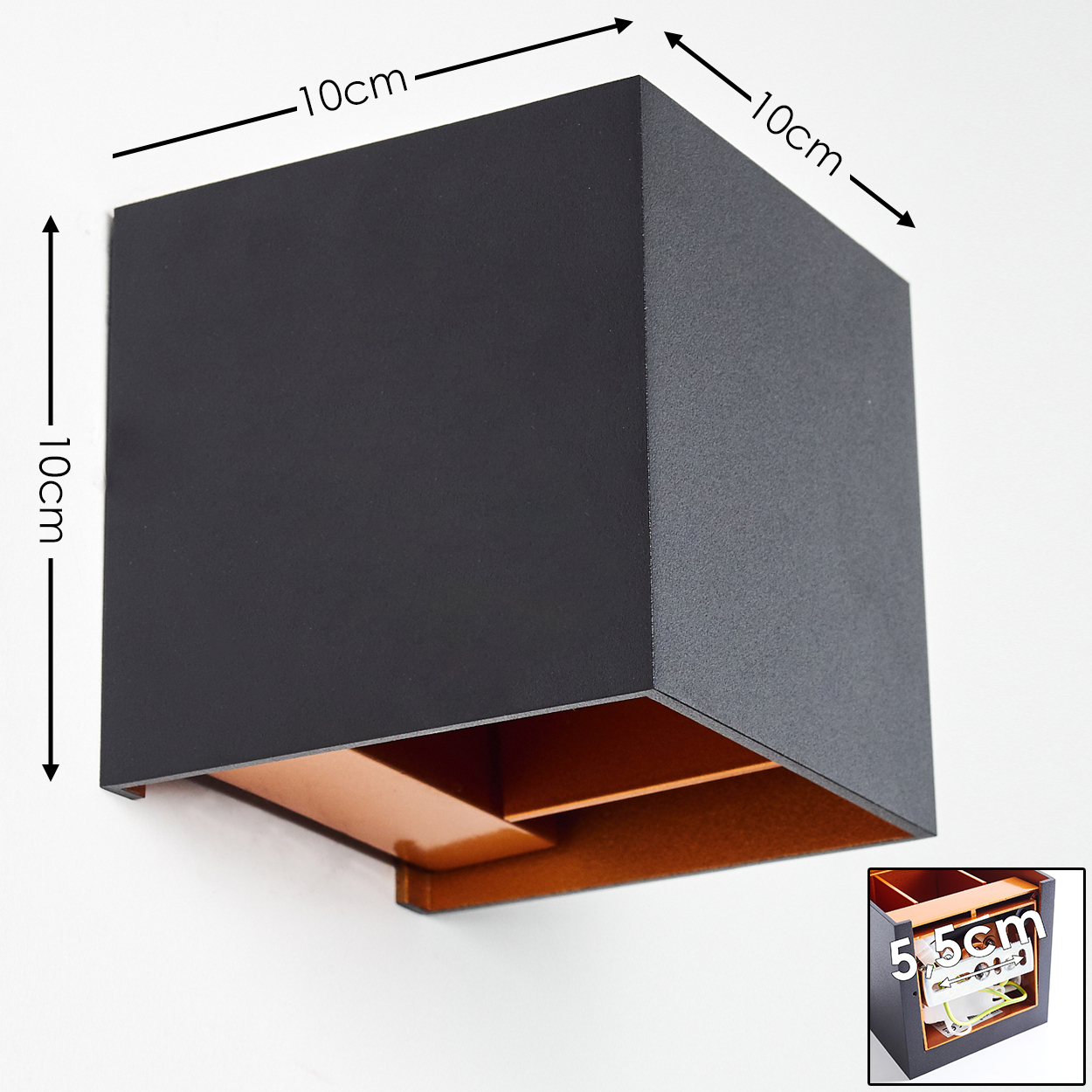 Eine quadratische, schwarze Wandleuchte mit kupferfarbenem Innenraum, montiert an einer weißen Wand. Abmessungen sind mit Pfeilen und Zahlen angegeben.